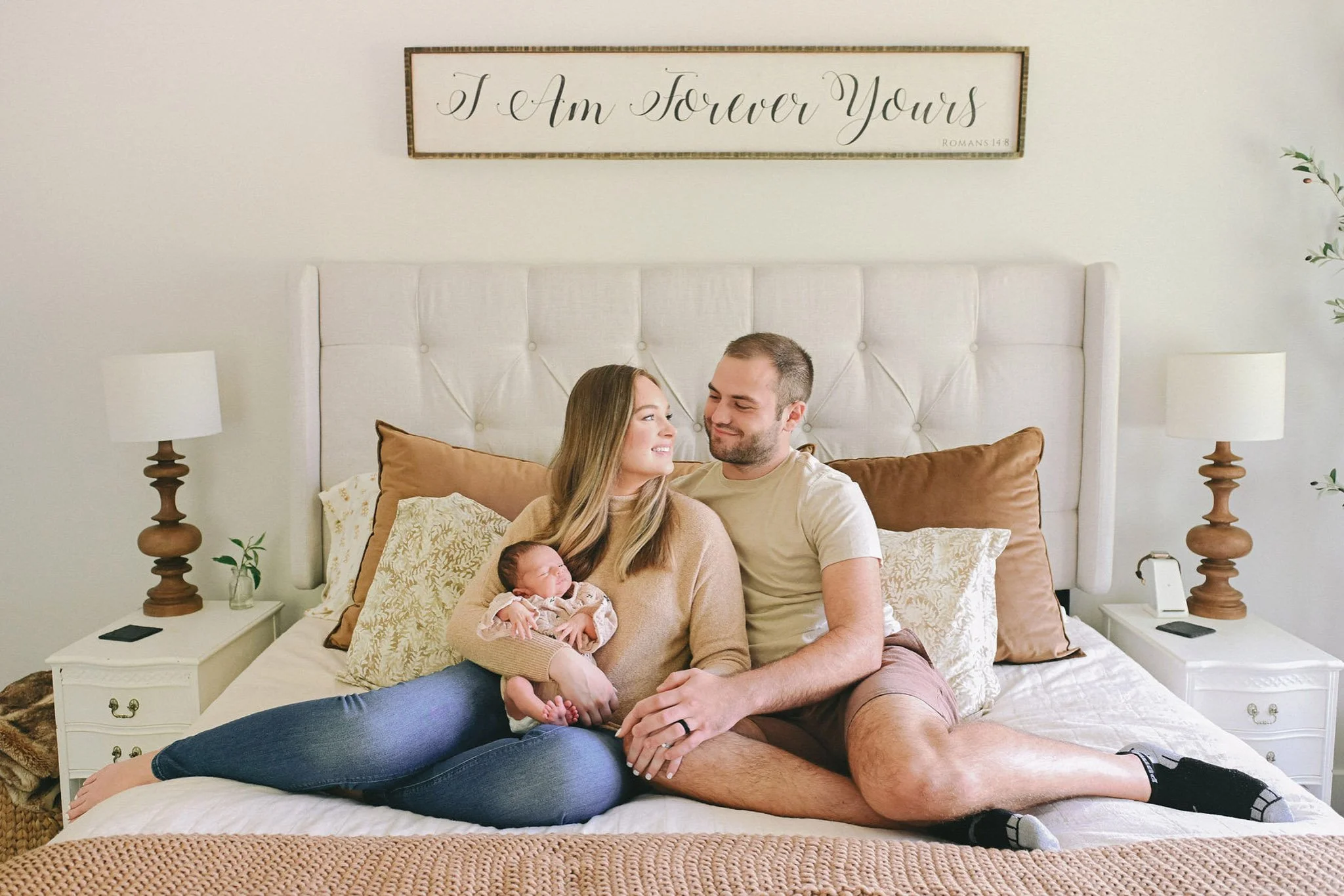 couple on bed with newborn baby during at-home session