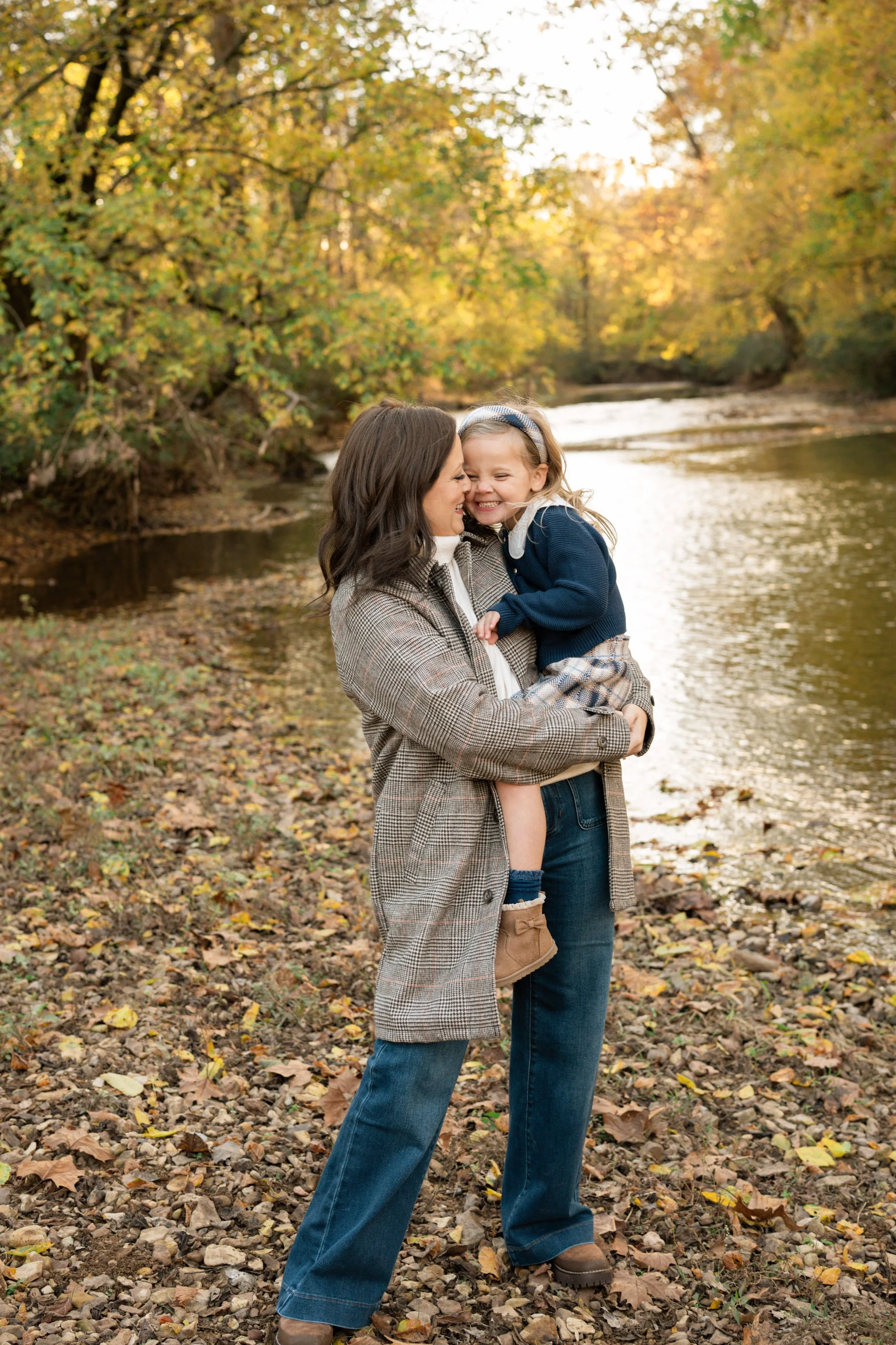 mother hugging her daughter next to a stream