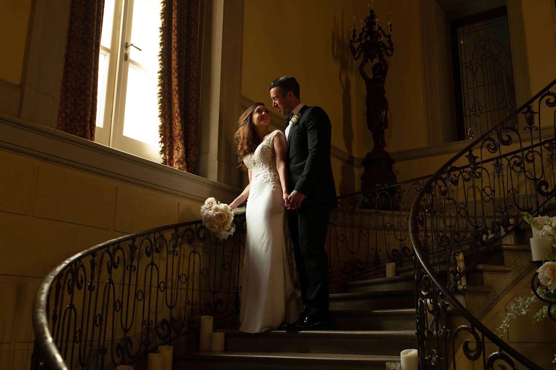 10_Bride_and_groom_on_stairway_Oheka_Castle.jpg