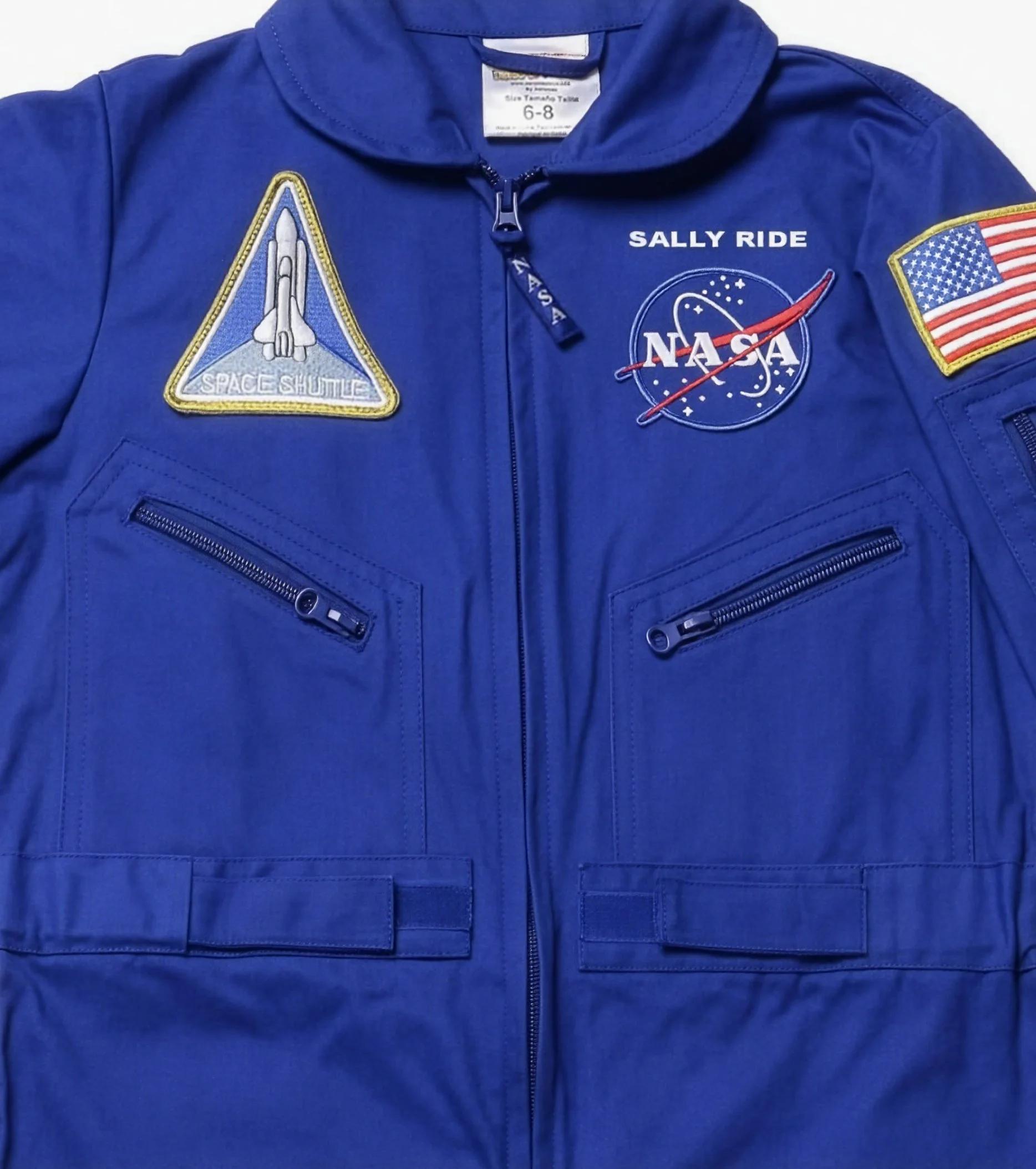 A blue NASA flight suit with a Space Shuttle patch, the NASA logo and zippered chest pockets: reference for the pockets, zippers and patch layout.