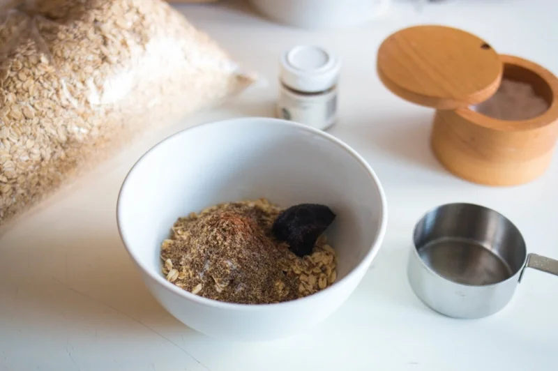 Old-fashioned oats, flax, cinnamon, sea salt, and date paste in a bowl before adding liquid.