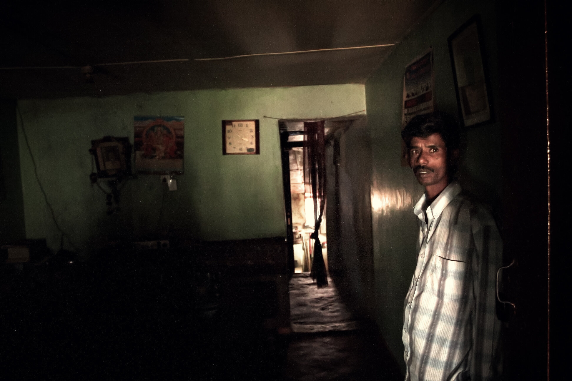 A worker at the entrance of his “line-room”- long structures divided into single rooms, one per family.   