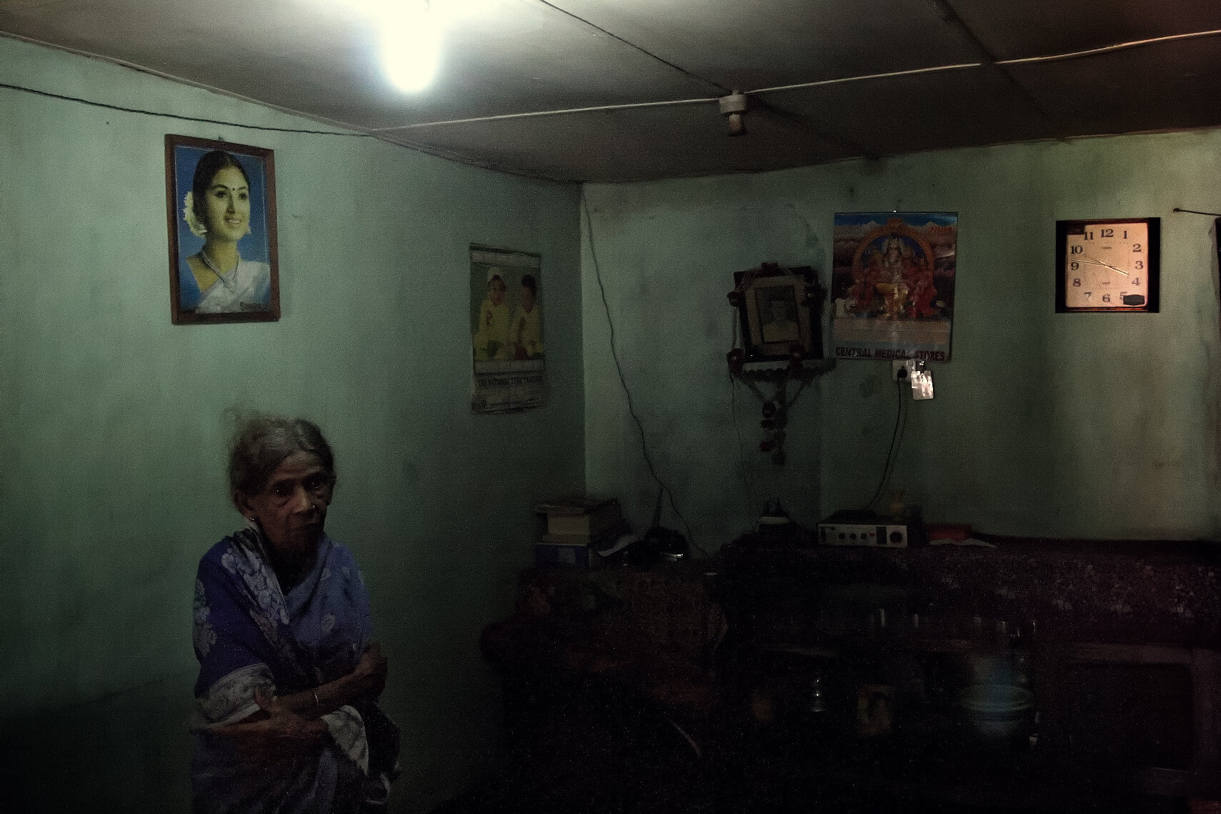  His mother in the “living room”. As families have grown, the tiny units have been further partitioned.   