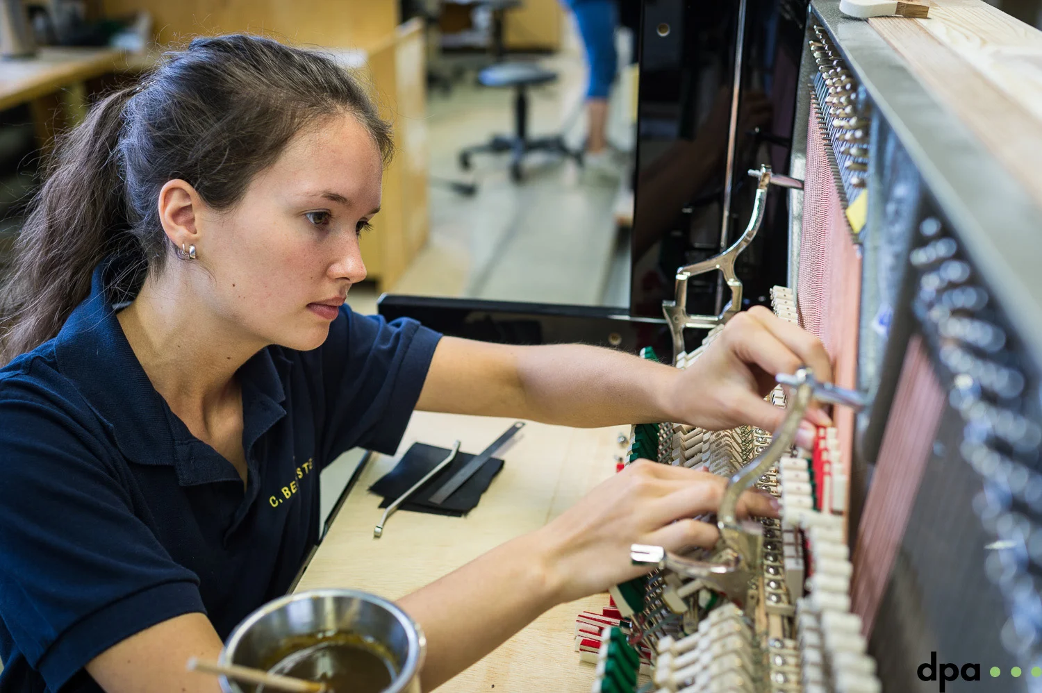 Auszubildende Paula Kiechle Leimt Daempfung auf in der technischen Pianoabteilung am 06.09.2017 in der C. Bechstein Pianofortefabrik AG in Seifhennersdorf (Sachsen).
//Foto: Pawel Sosnowski