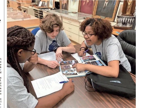 Current Austin-East students look at an Austin-East yearbook from 1989. Breanna Morris, Quincy Fields and Ahya Moreno are surprised to see that the school itself hasn’t changed that much, though the faces certainly have. (source) CAROL Z. SHANE/SHOPPER NEWS