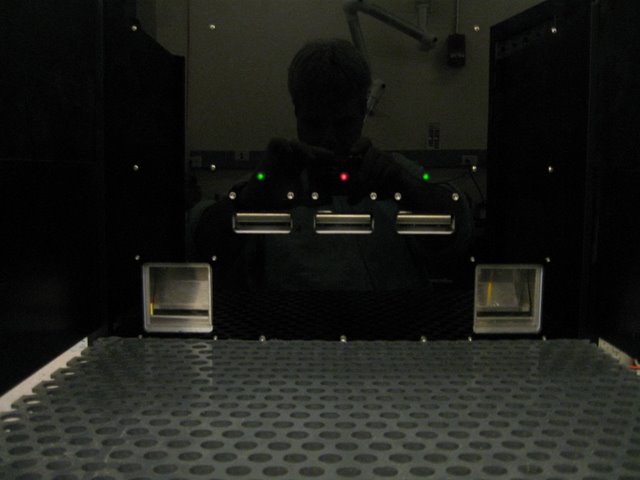Uchida Lab: A rodent behavioral chamber designed to measure the subject’s value of immediate and delayed reward. Variable numbers of food pellets can be delivered to each food window, access to which is under temporal control. Retractable levers report the animal’s response.