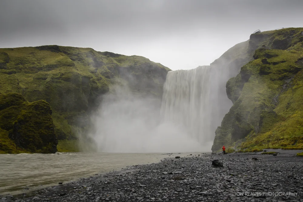 Skogafoss Waterfall, Iceland. Though this image was made at mid-day, the heavy overcast clouds allowed me to use slower shutter speeds and have no issues with glare or reflections. I used the person in the red coat to show scale. (Nikon D600, Nikkor 18-35G, Sirui T-025x Carbon Fiber Tripod with C-10 Ball Head)