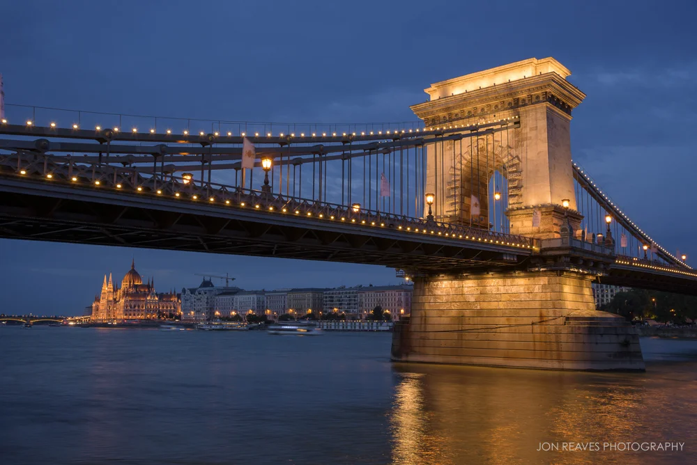 The Chain Bridge and Hungarian Parliament by the Danube at twilight.