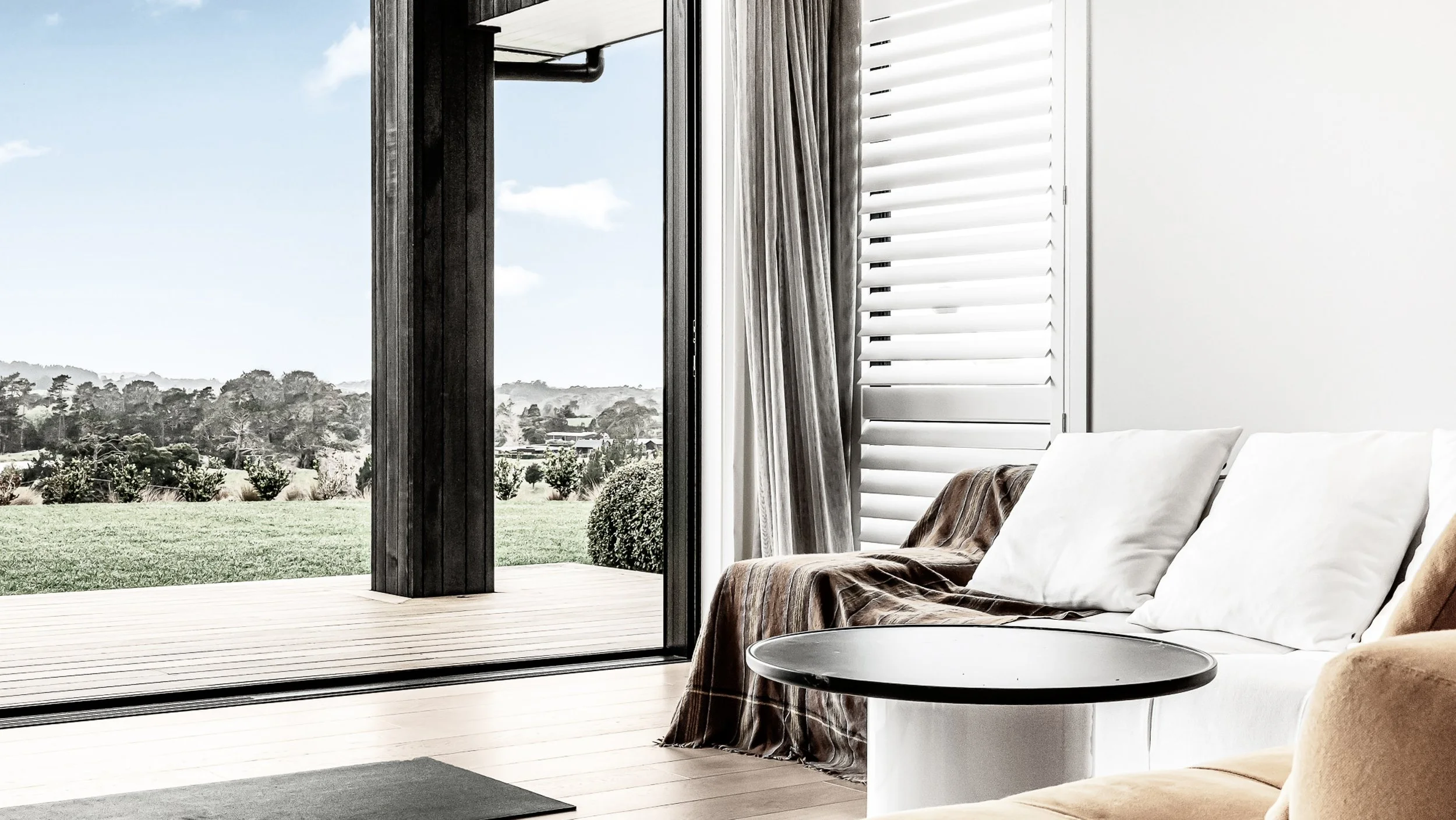 Living space opening to the rural landscape in a bespoke lifestyle home by Maddren Homes in Auckland