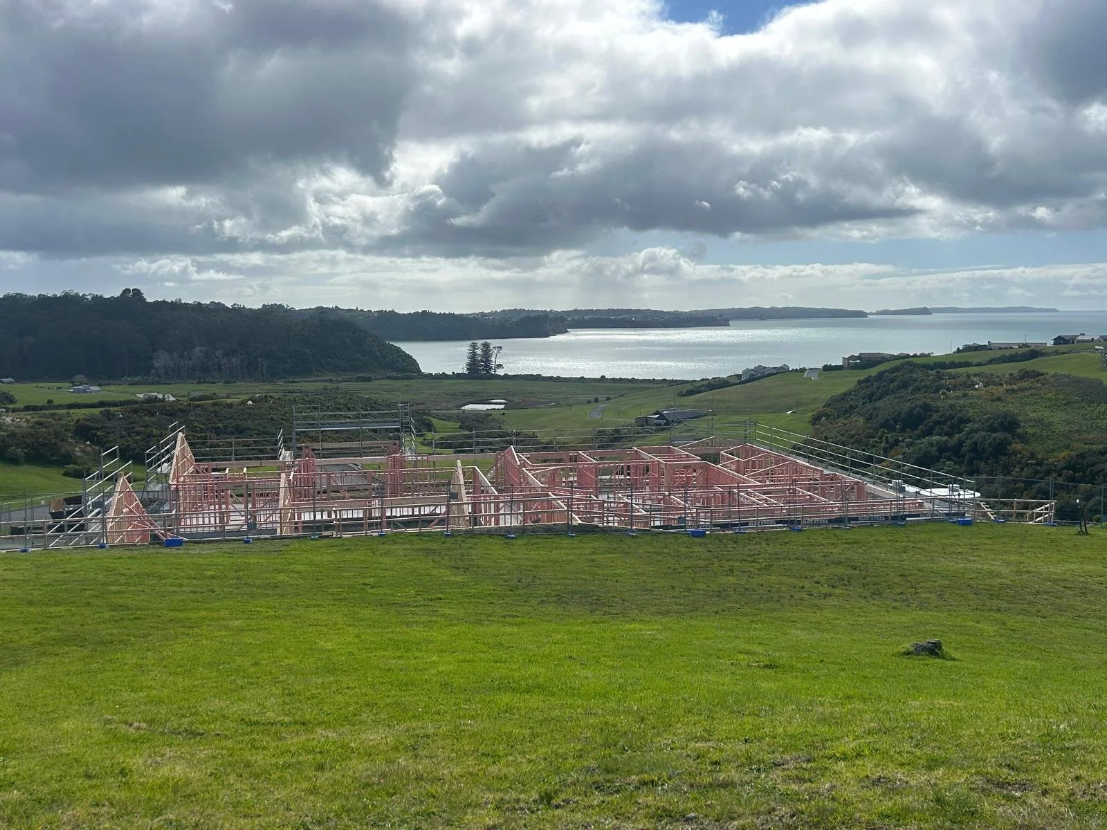 Maddren Homes project under construction on a sloping Weiti Bay site with coastal views