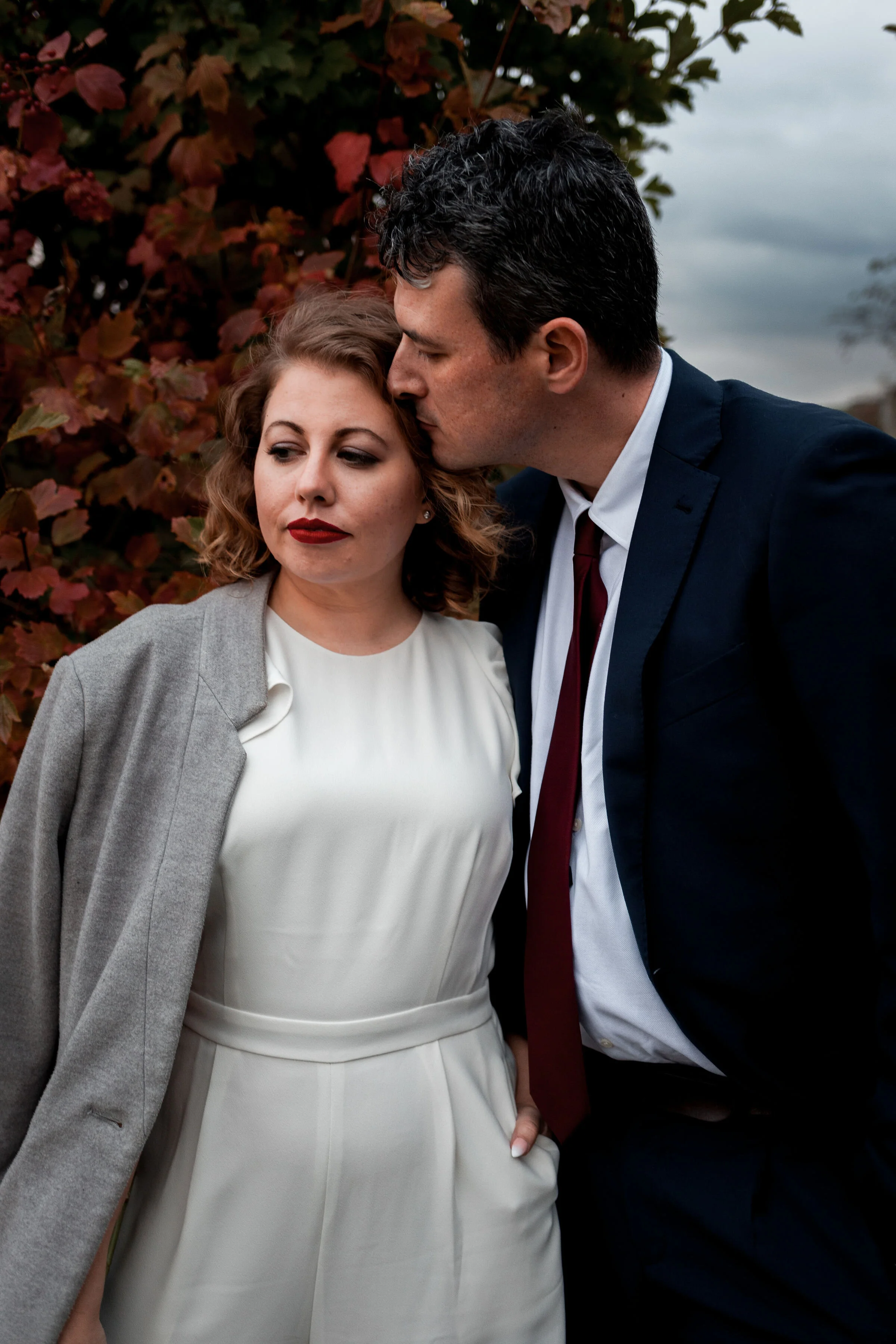 Groom kissing bride on forehead.