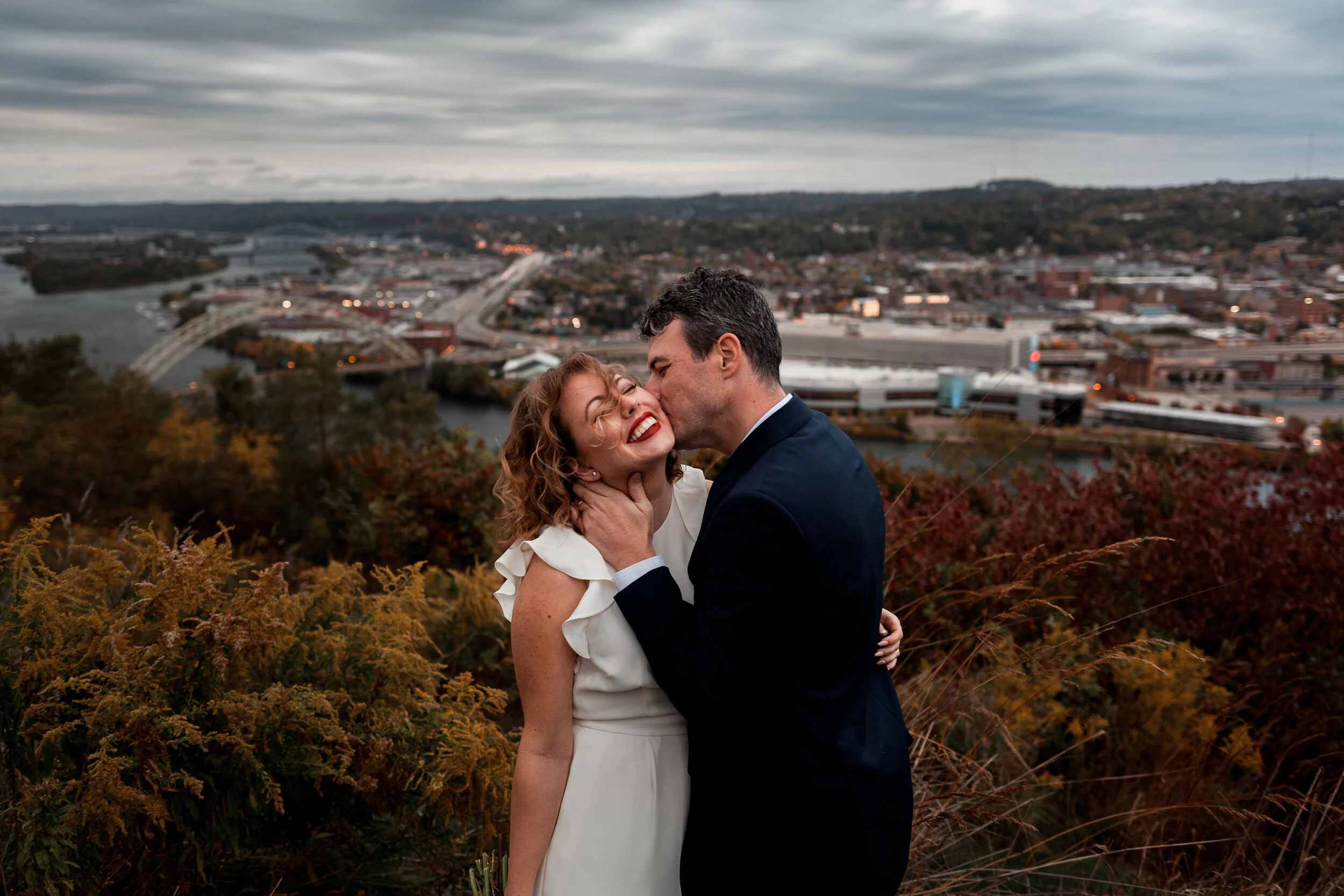 Bride being kissed by groom on Mt Washington in Pittsburgh.