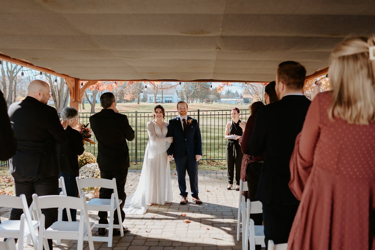 Bride and groom stand in front of guests after saying I do.