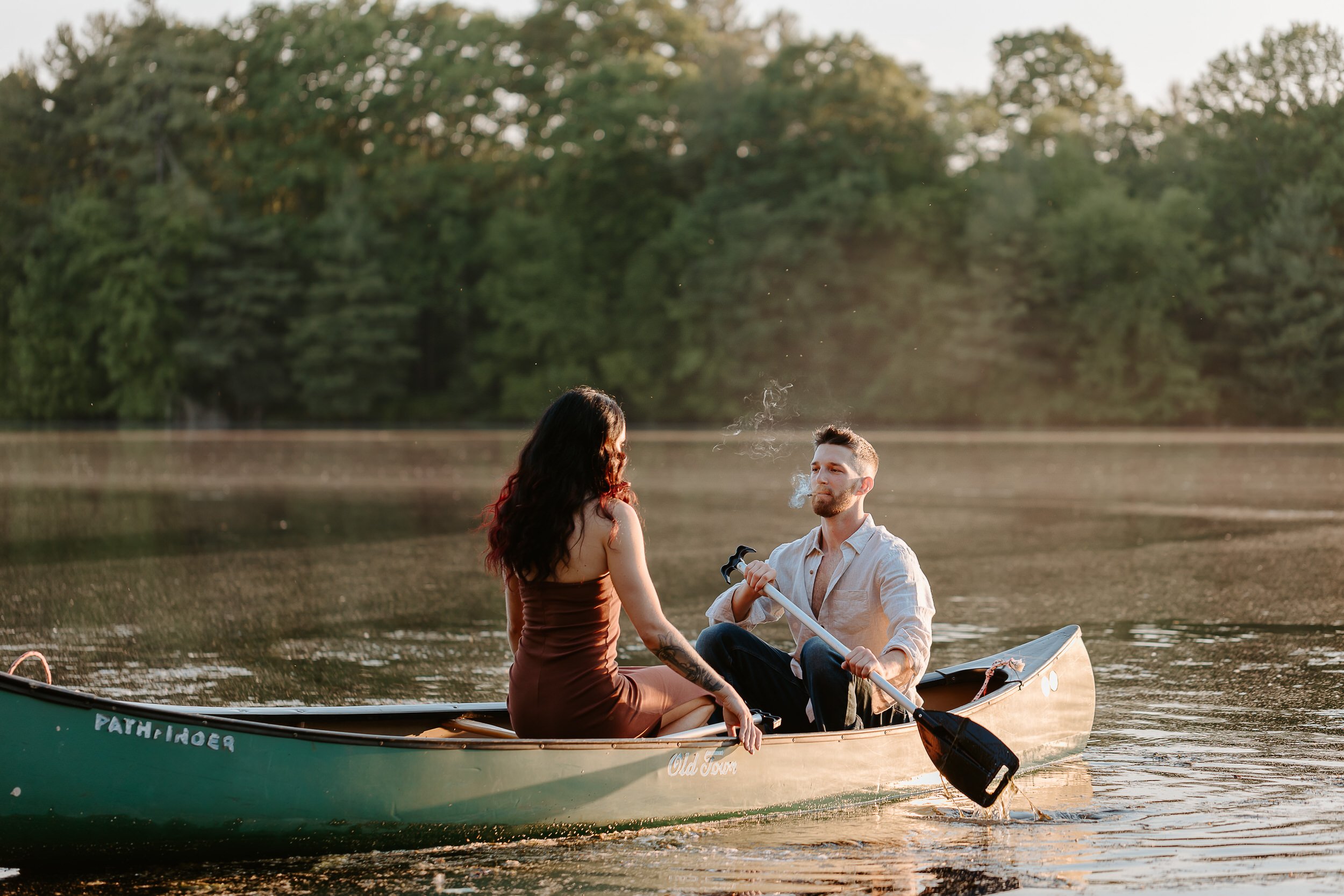 Man and woman sit in canoe on the lake.