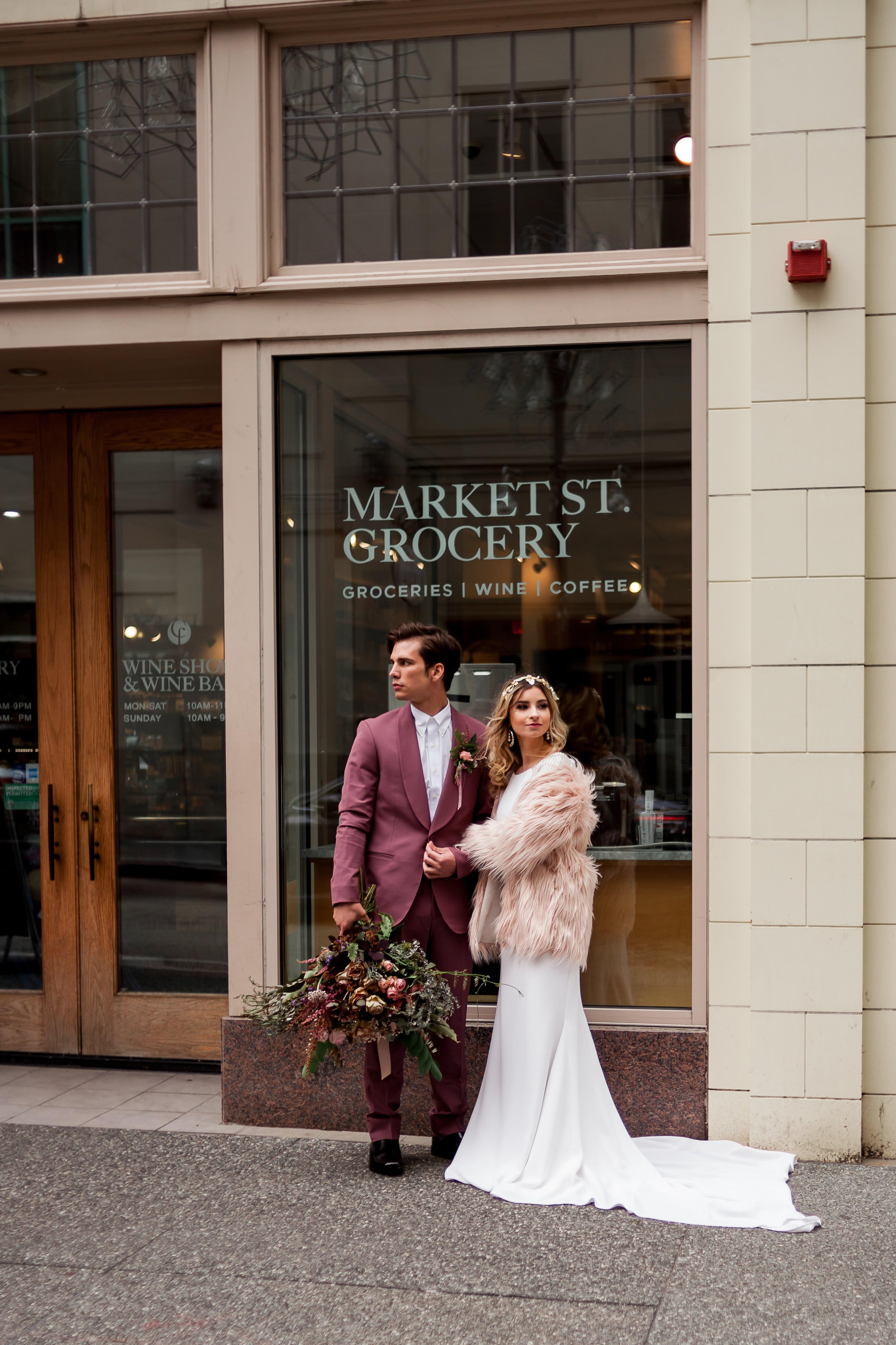 Bride and groom stand embracing each other in front of Market St. Grocery.