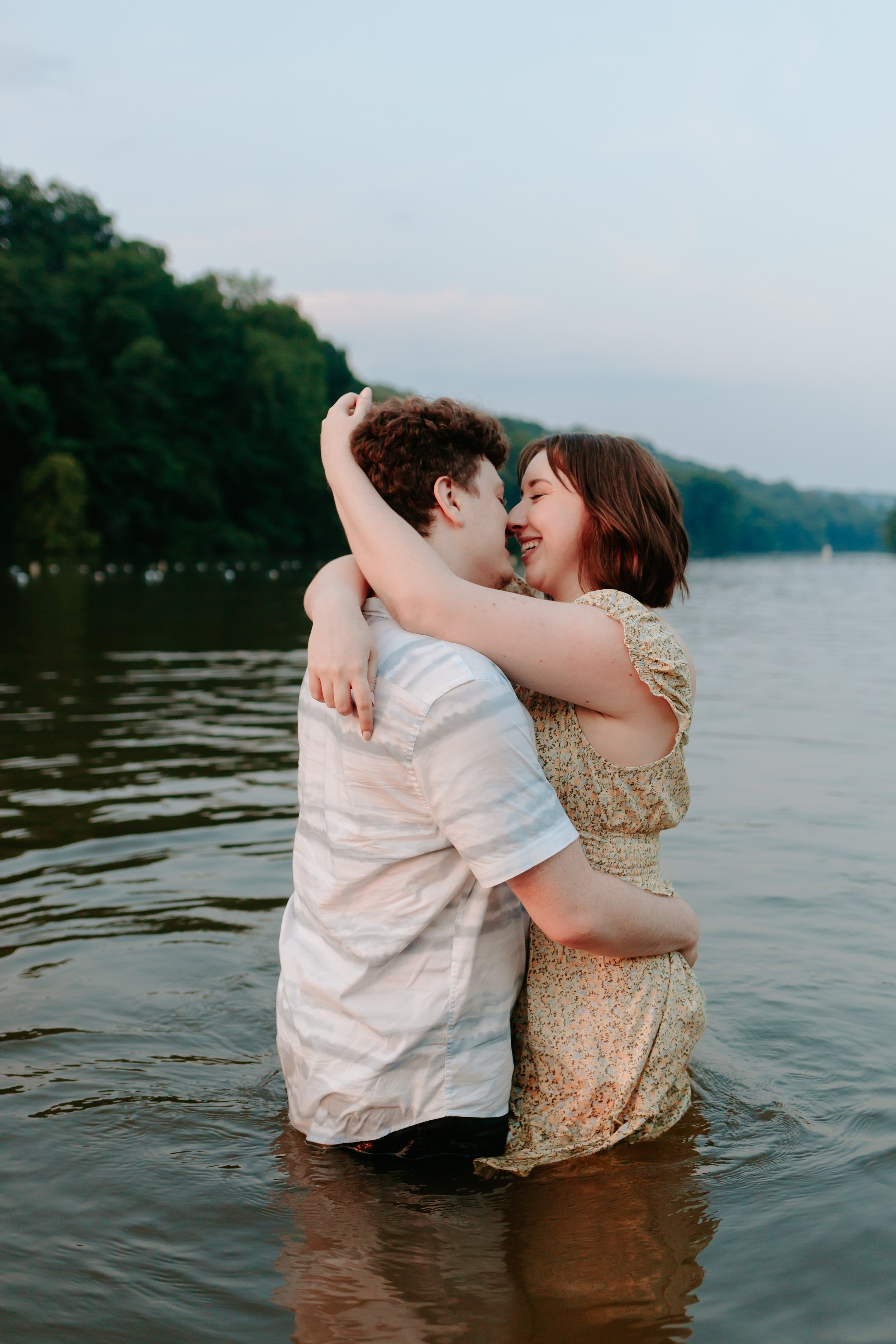 Couple embraces while standing in lake.