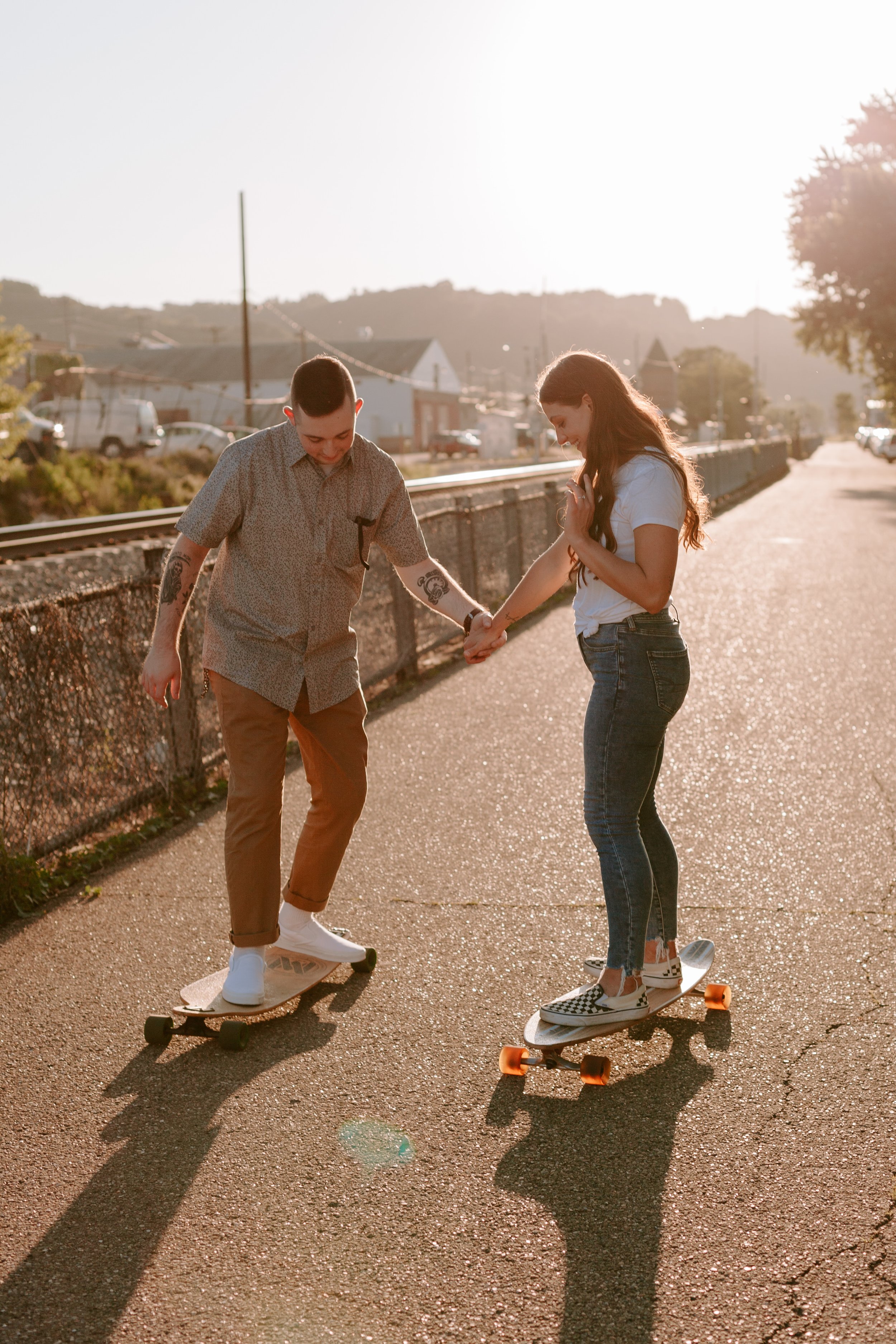 Woman and man longboard together during sunset.