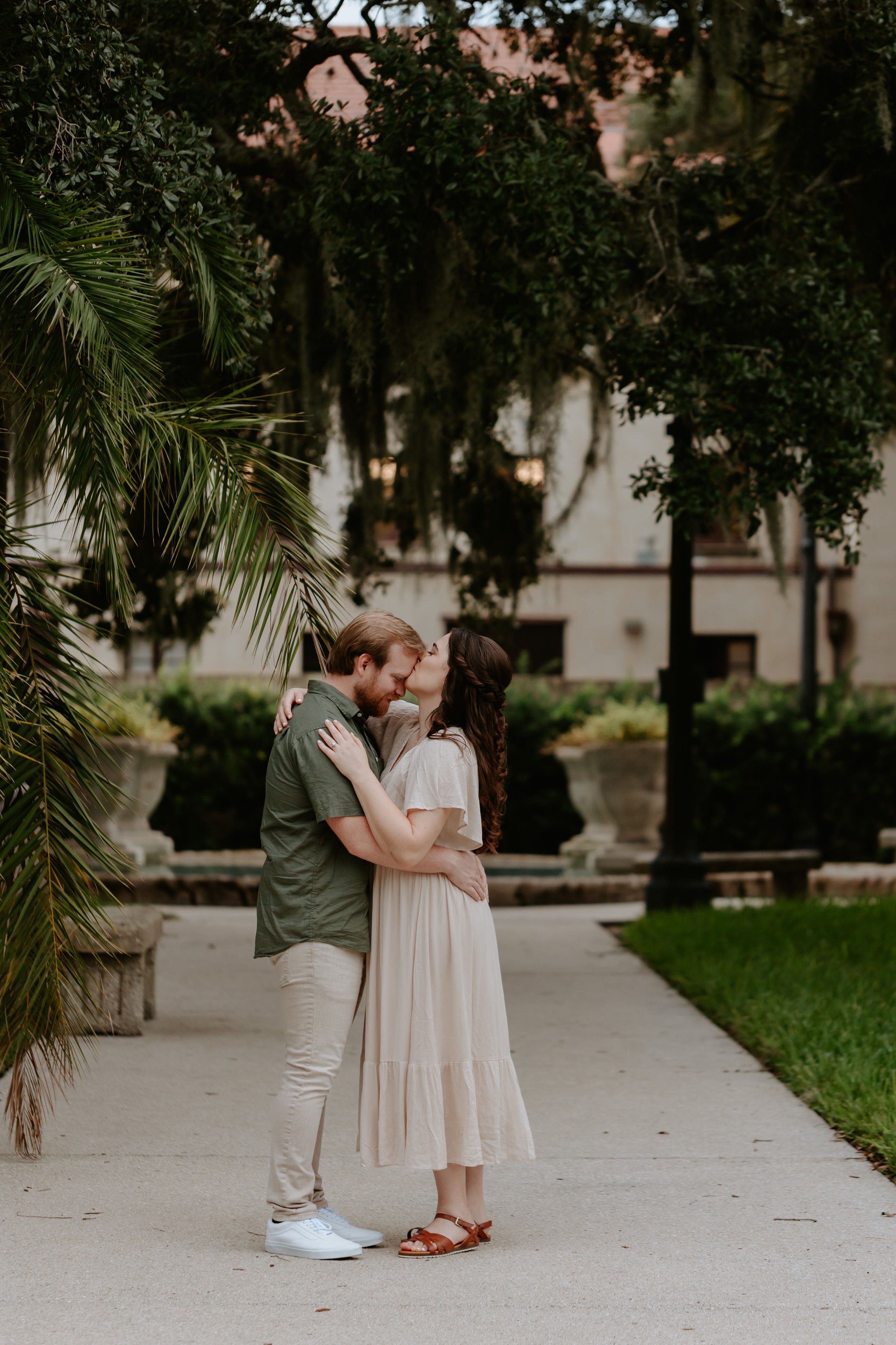 Woman embraces man and kisses his forehead. 