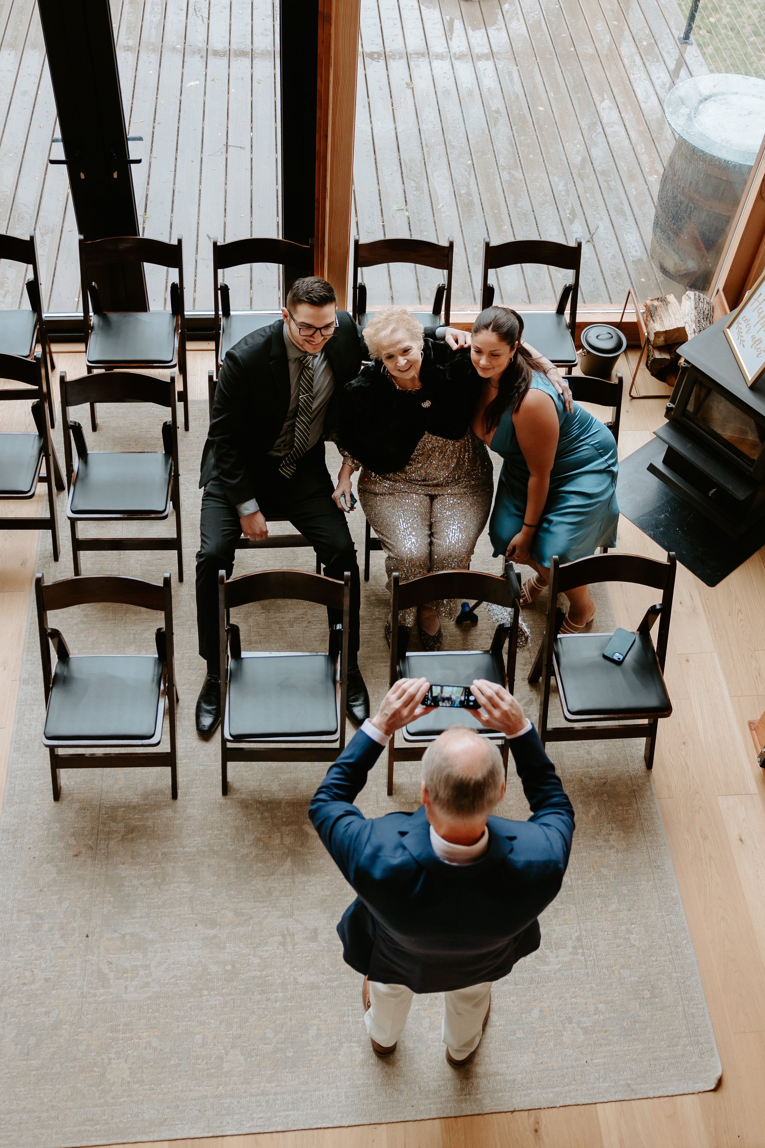 Man takes photo of family members at a wedding.