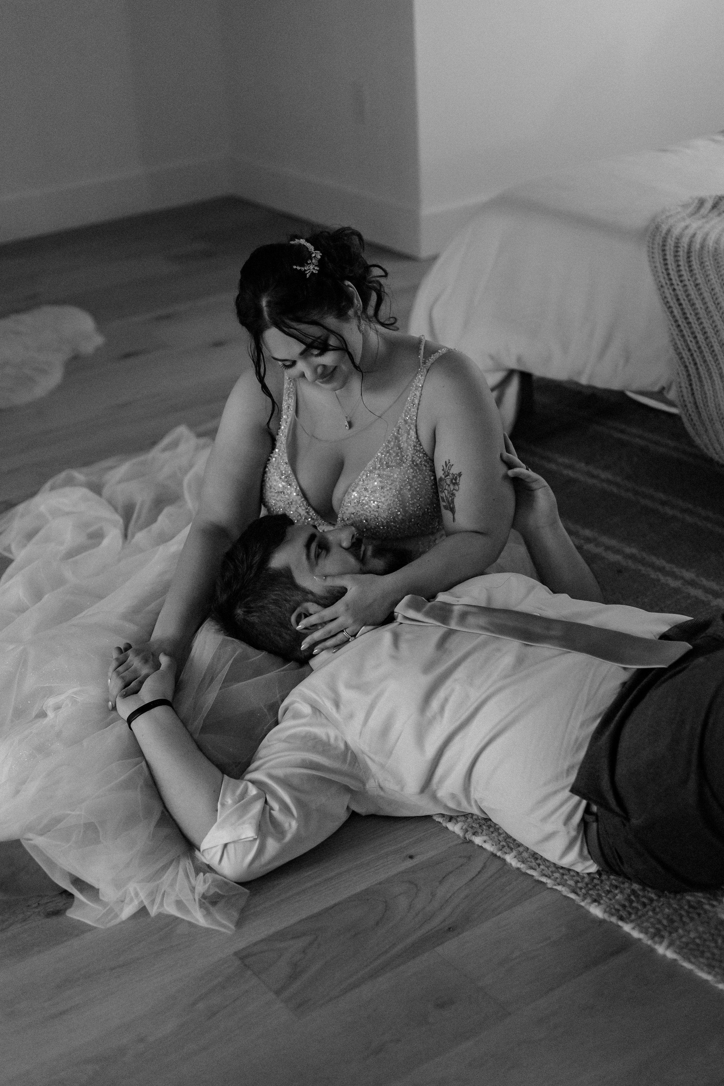 Bride and groom lay on floor together.