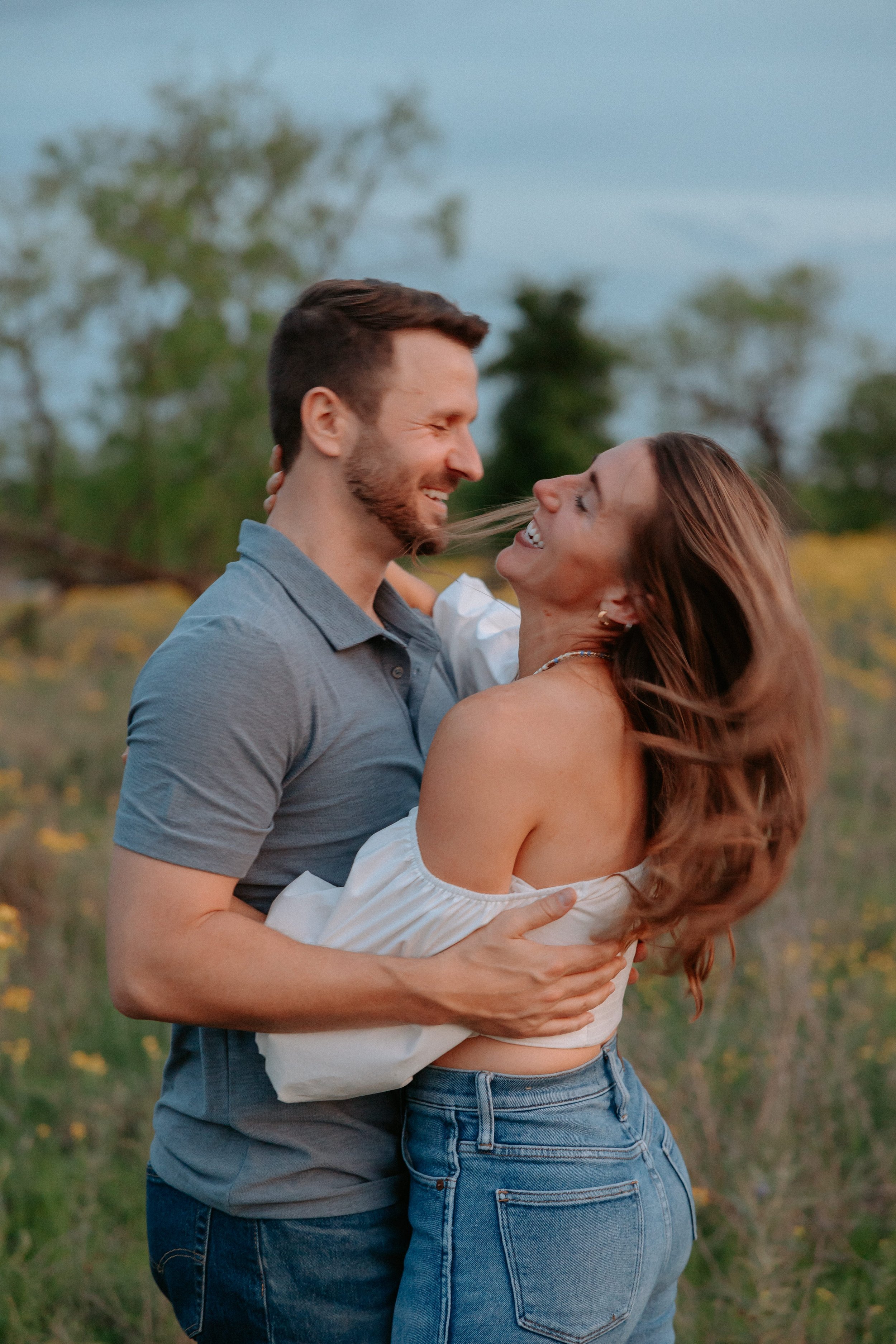 Man laughs with a woman in a field.