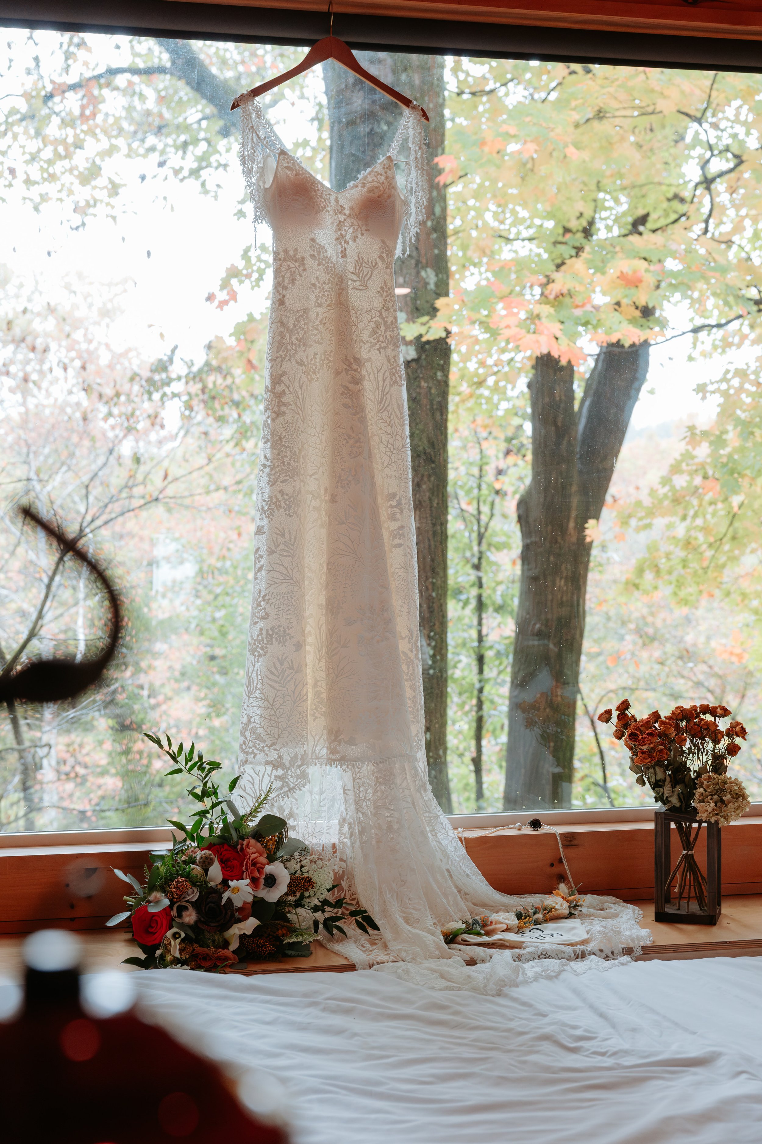 Wedding dress hanging in a window.