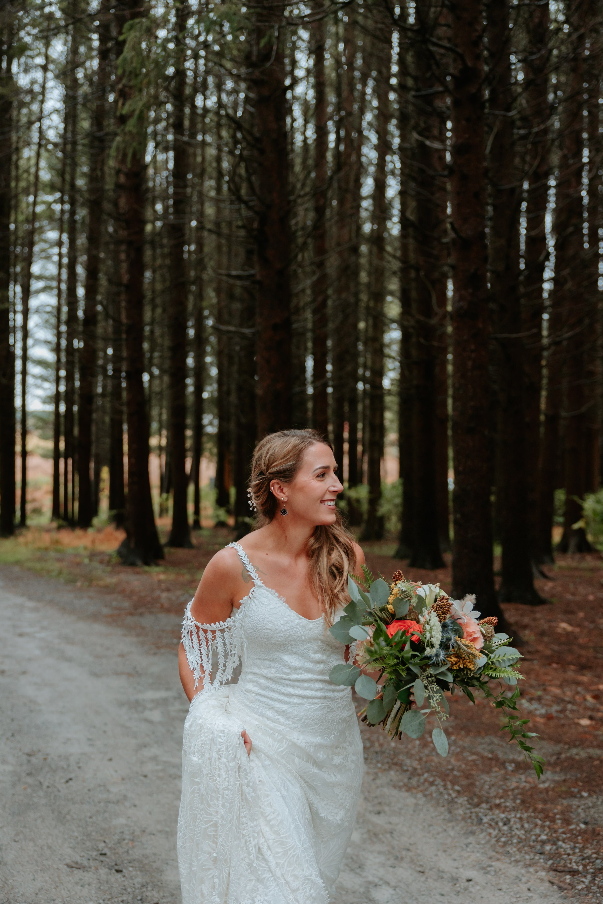 A bride walks down a gravel road.