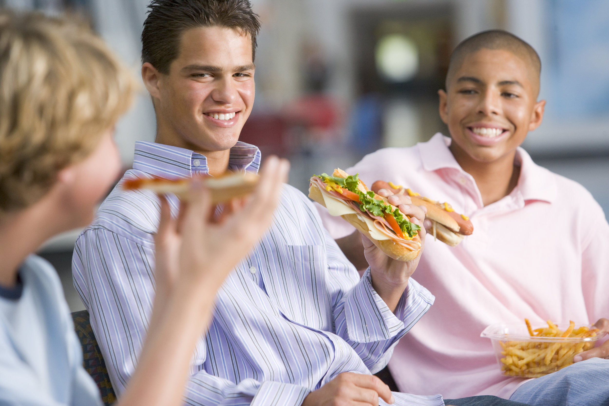 teenage-boys-enjoying-fast-food-lunches-together_BYQe0Crs.jpg