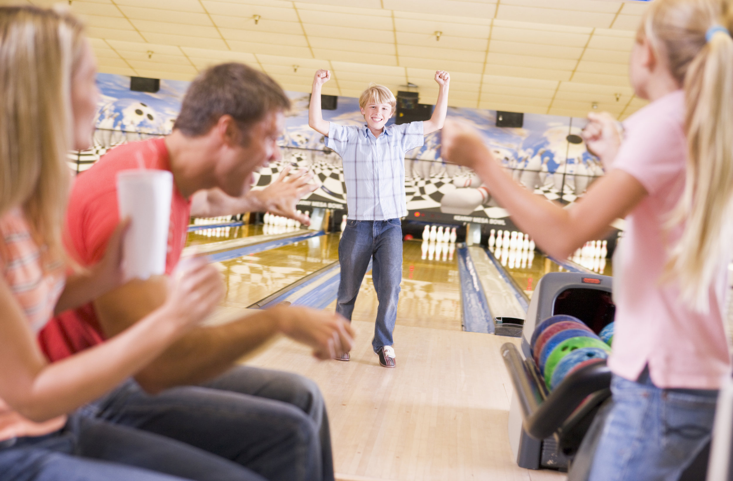 family-in-bowling-alley-cheering-and-smiling_HY0FN6ABj.jpg