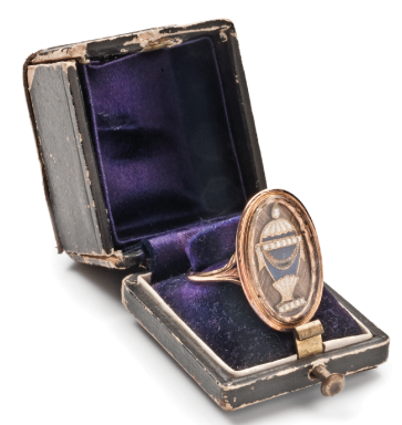 Mourning ring in original box dated 22nd April 1784. The gold, pearl and blue/white enamel urn sits upon hairwork