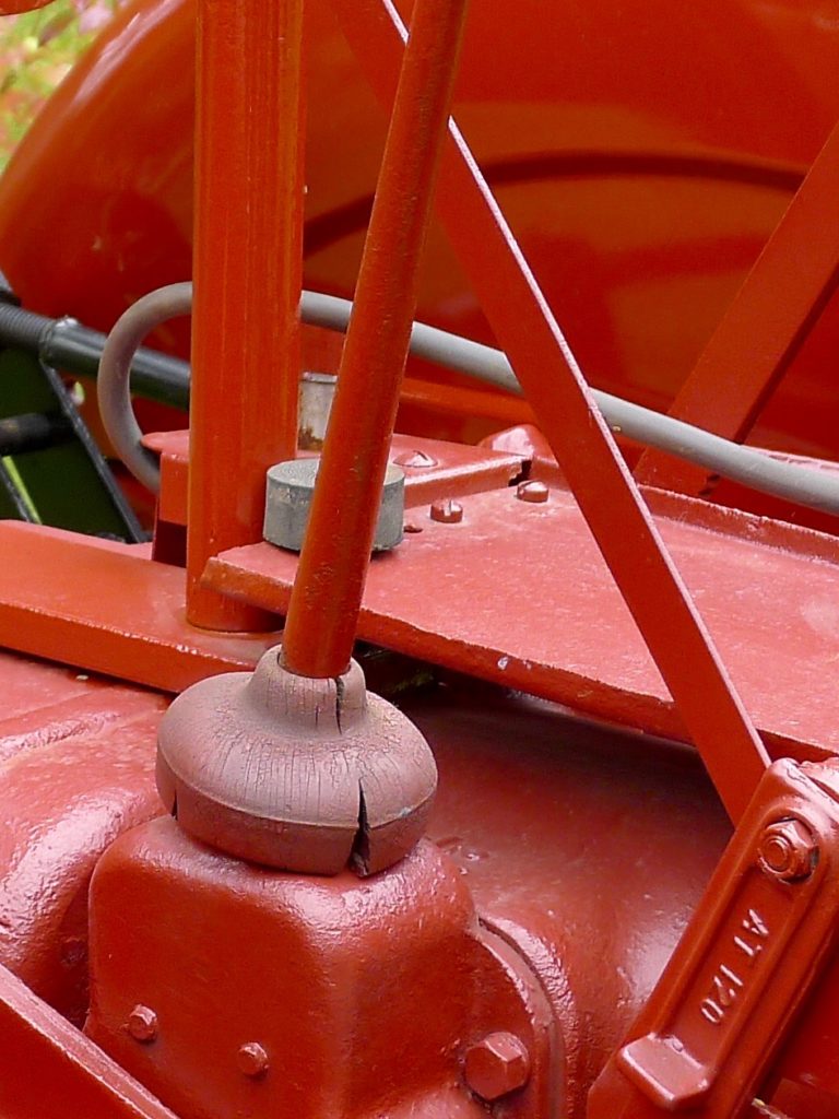 The rubber waterproofing around the base of this gear shift lever was intended to prevent water from getting into the transmission and gear train, but it is cracked and deteriorating. Some tractors have a factory rubber seal under the shift pattern, which can also fail.