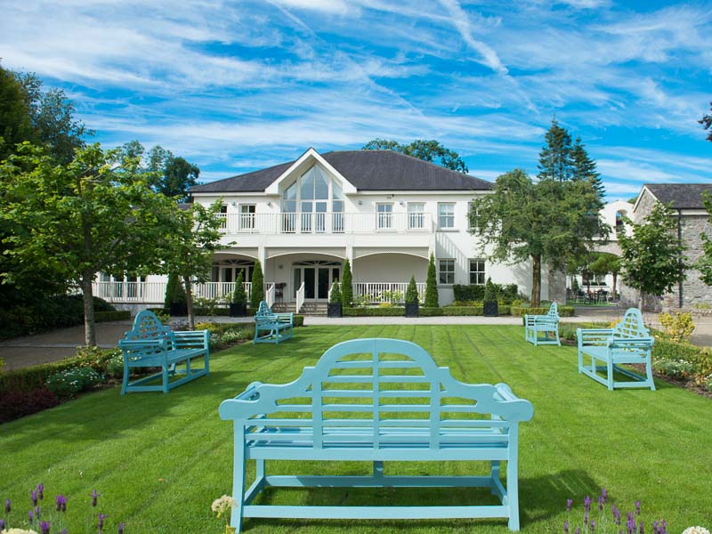 Tulfarris Hotel and Golf Resort exterior of manor house with benches.jpg