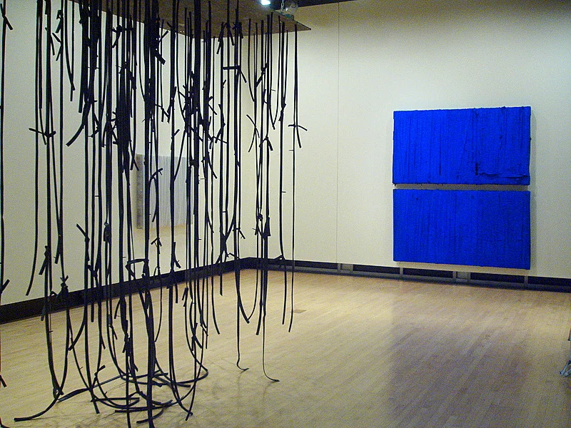Foregound: Strut (Albany) , 2008, rubber inntertubes, hanging of wooden armature, 144 x 96 x 48 inches. Background: Christiane , 2008, pigment on rubber inntertubes over wooden armature, 96 x 96 x 5 inches, (the blue piece in back) (Position exhibition shot, Opalka Gallery, Russel Sage College, Albany, New York)