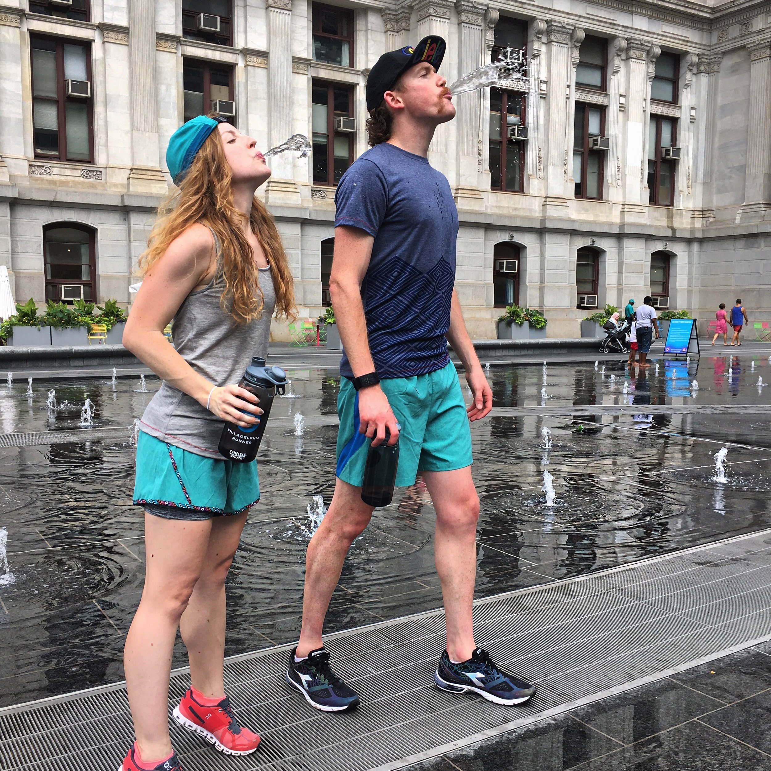 Christine and Breandan are staying hydrated and keeping cool in Ciele Athletic caps and Run Janji apparel. On Running Clouds & Diadora Mythos Blueshield shoes also pictured. 