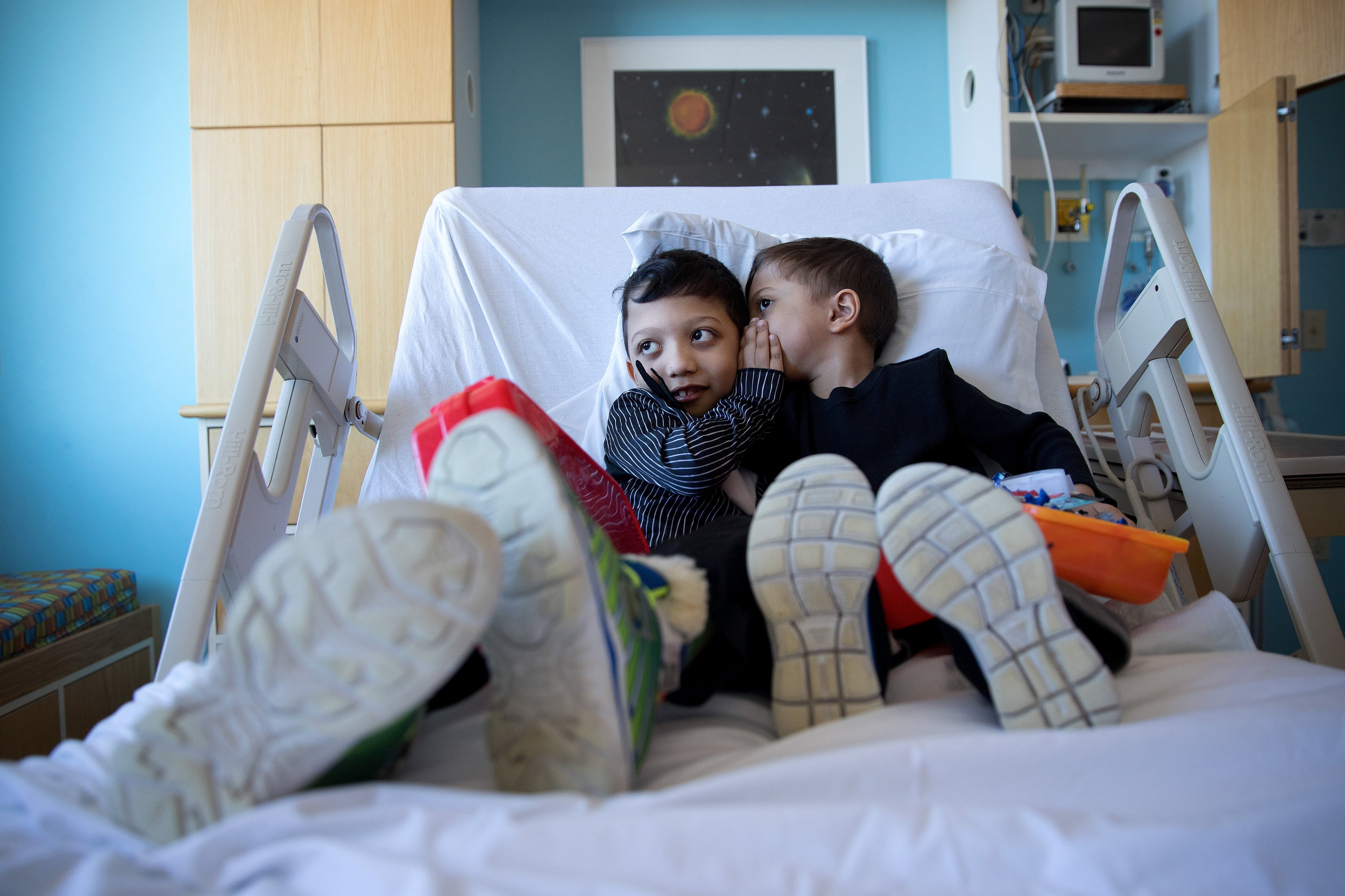 At Children's Hospital & Medical Center, Arshaan, left, and Jahan tell each other secrets before undergoing infusions to regulate high blood calcium levels. "Like all rare diseases, there are difficulties that the family has to undergo. There are sacrifices that we make as a family," their mother said.