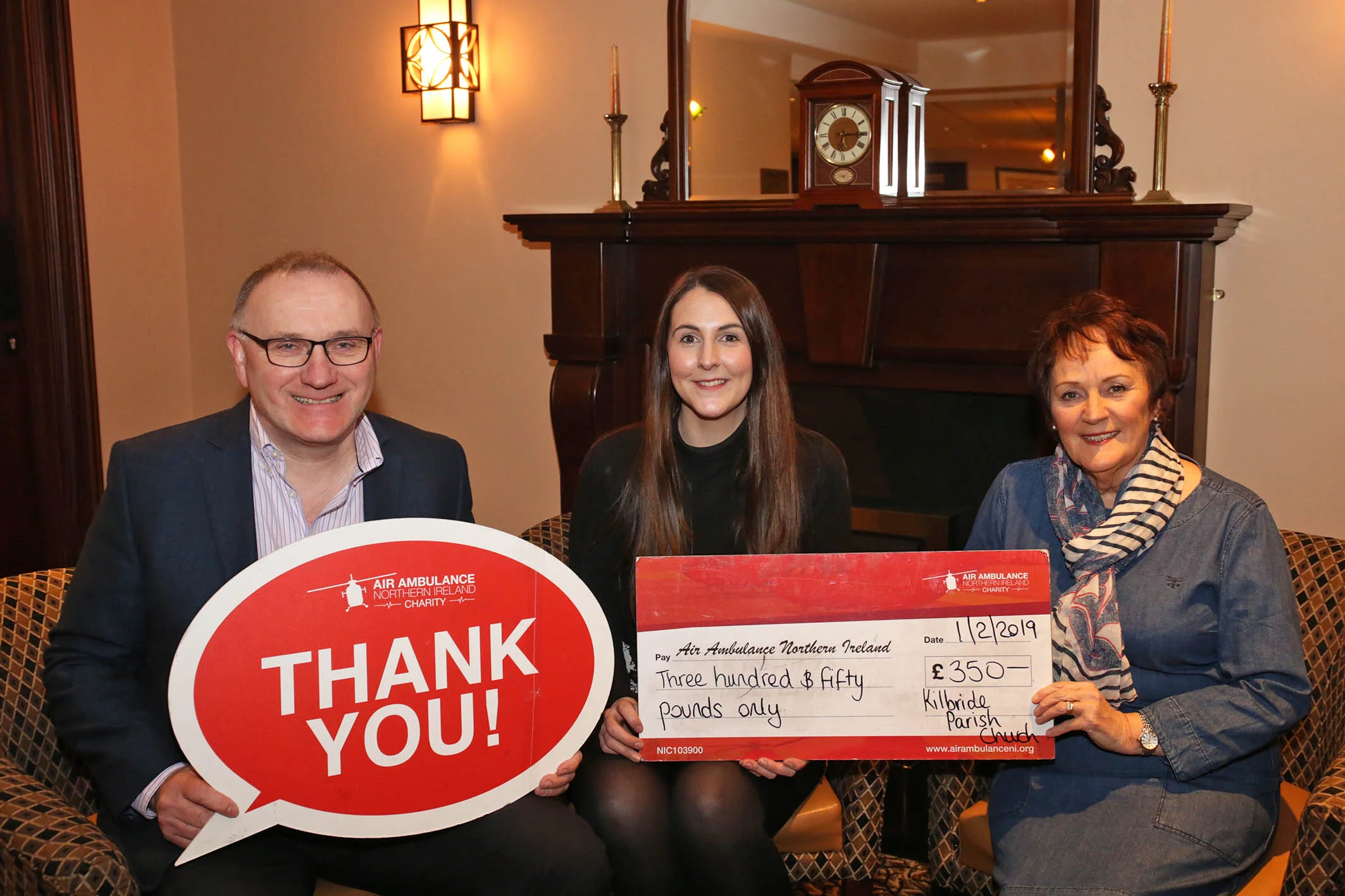 Grace Williams, Air Ambulance NI, receives a cheque from Kate Henry and David Holmes.