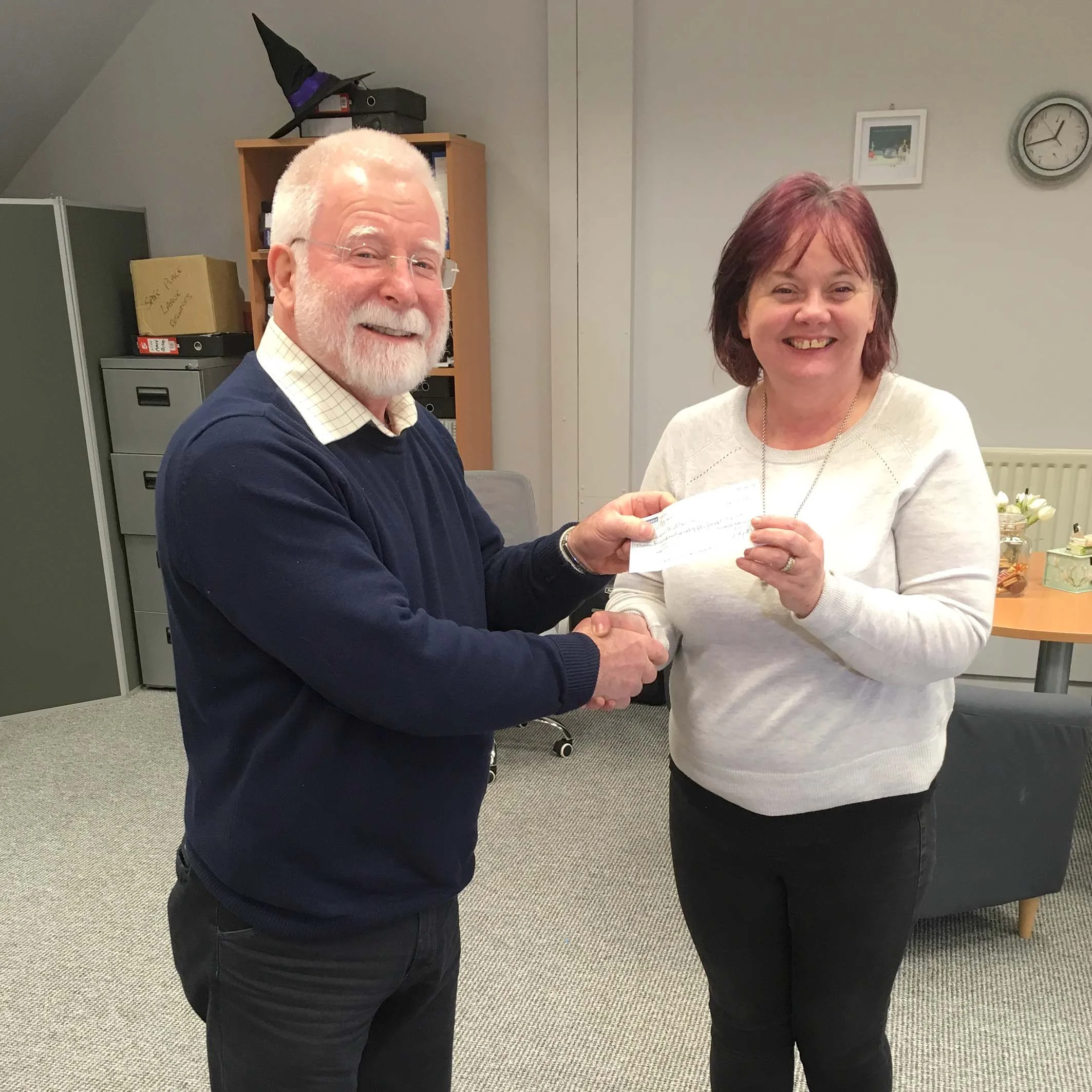 Ivan makes the presentation to staff member Fay Tilson, Women’s Aid, in their Larne office.