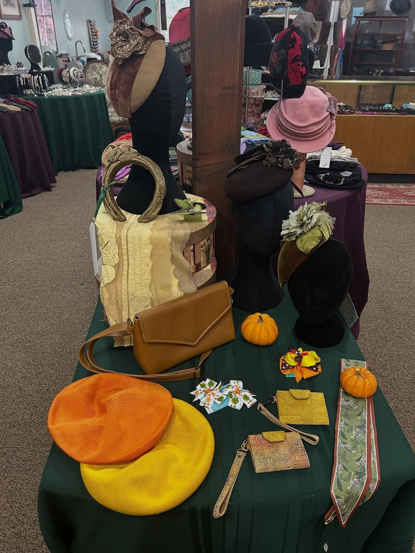 The small table at the front of the shop has been changed from Halloween to Thanksgiving finally! Small, very wearable button and teardrop fascinators, a silk &ldquo;turban headband&rdquo;, berets, cork change purses with wrist straps, vegan leather 