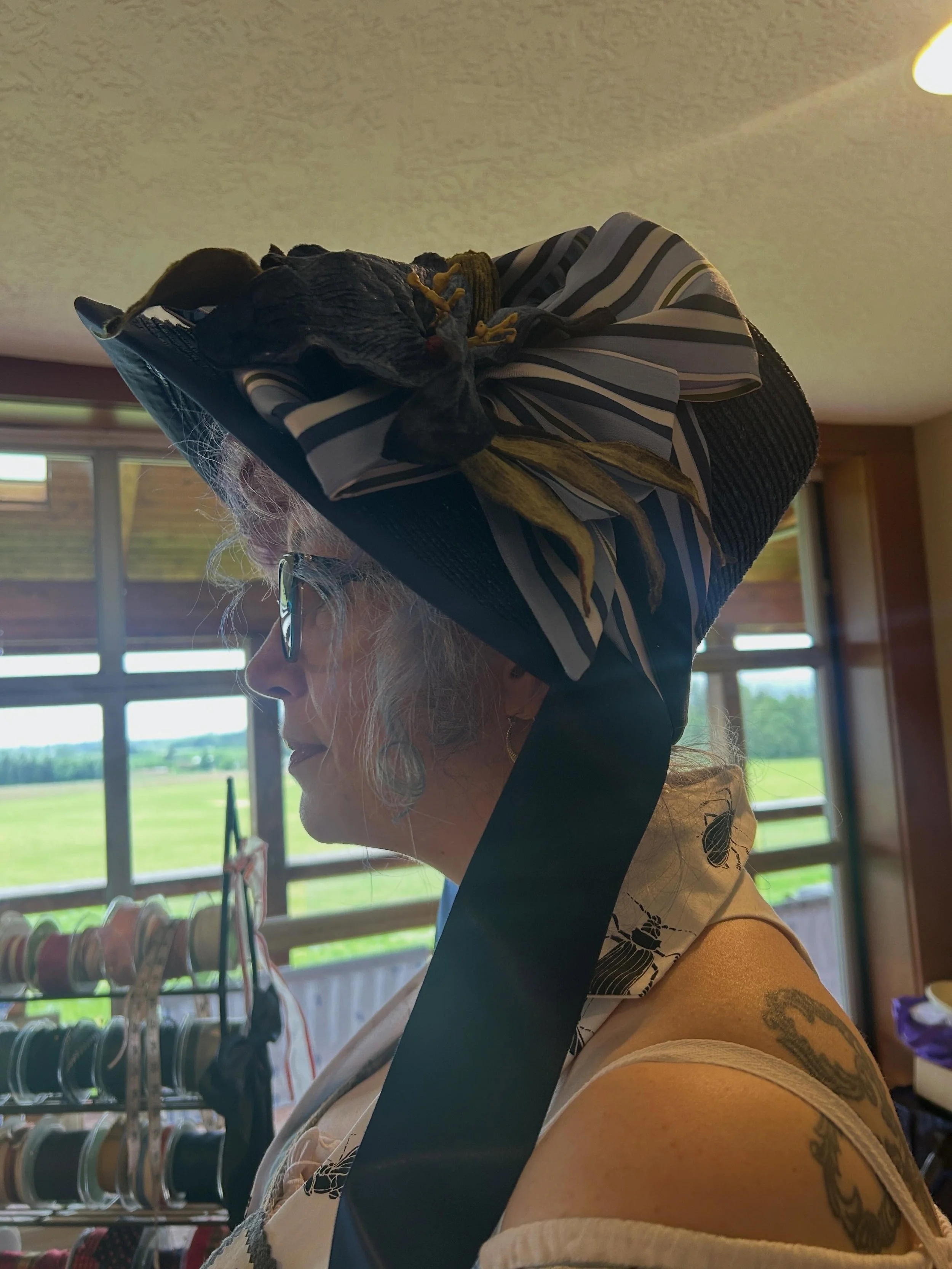 I love it when a hat &ldquo;picks&rdquo; its new owner. This navy straw braid bonnet was actually designed with Marietta in mind and she picked it up as soon as she saw it and claimed it as hers. Perfect! Love the striped silk trimmings and the large