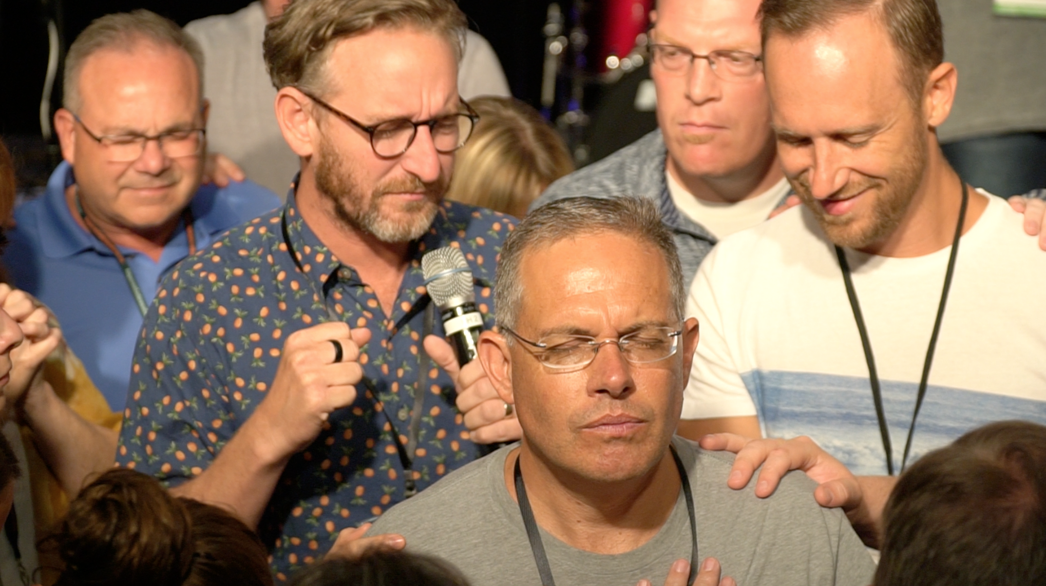Tom Shaw, Brice Fogle, and several others gather around Scott Marques during the night of prayer at Celebration Southeast.