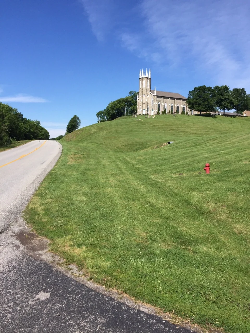 As always the photo doesn't give a good sense of the expanse of the hill and the lawns and the graveyard on the matching hill to the right. The Priory Building just juts out and dominates the land. It's the Saint Rose Priory, operated by the Francis…