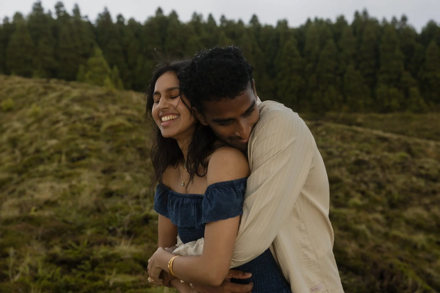 joyful couple hugging after a marriage proposal in the Azores landscape