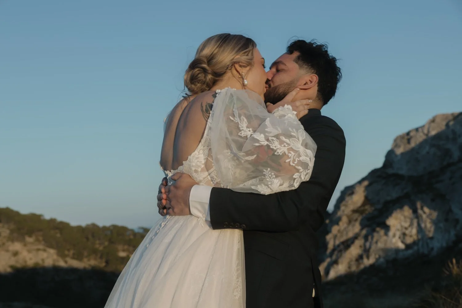 Bride and groom sharing their first kiss after a cliffside elopement ceremony in Mallorca.
