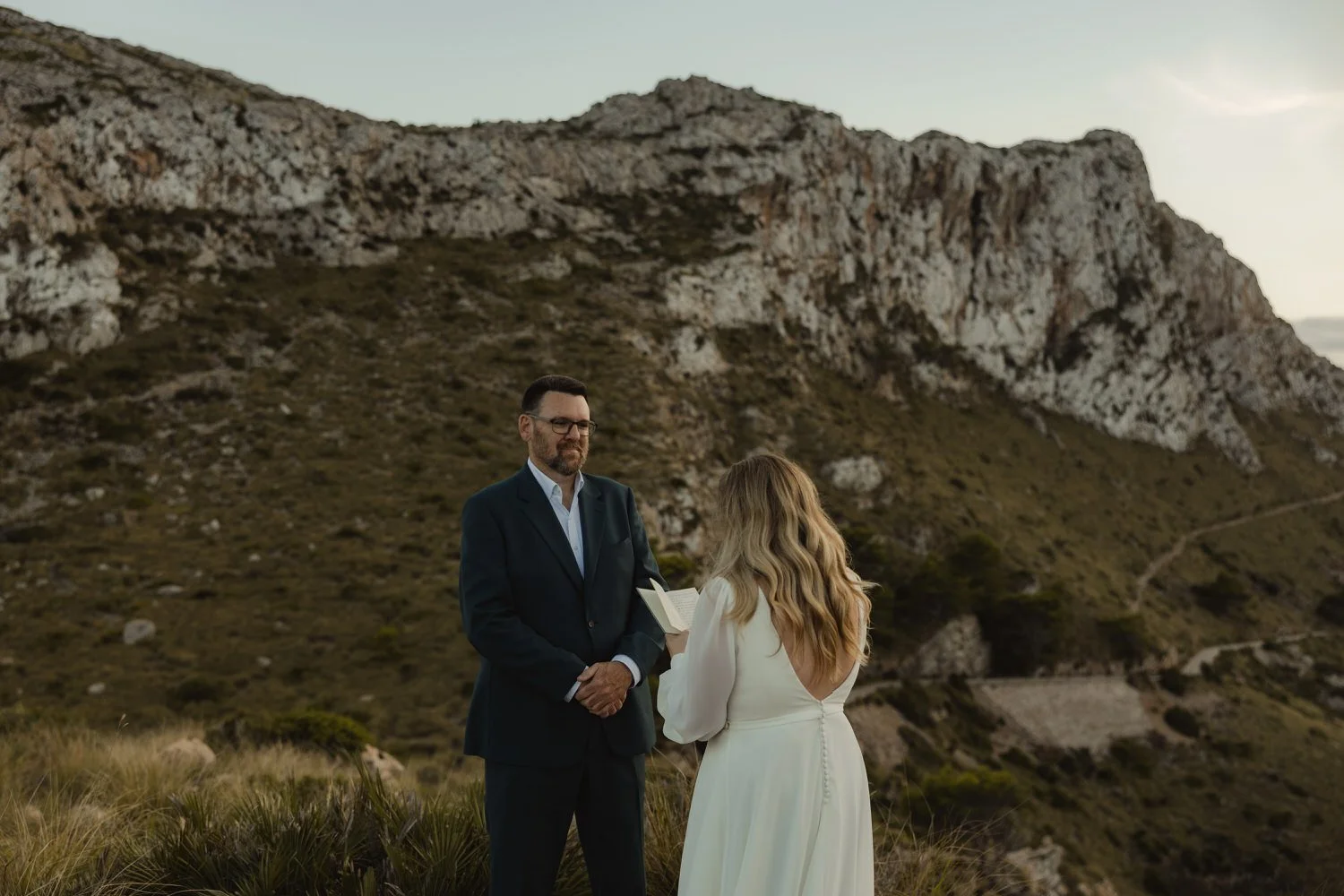 Bride reading wedding vows to groom during an intimate elopement in Cap de Formentor, Mallorca — photographed by destination wedding photographer Adrián Vilanova