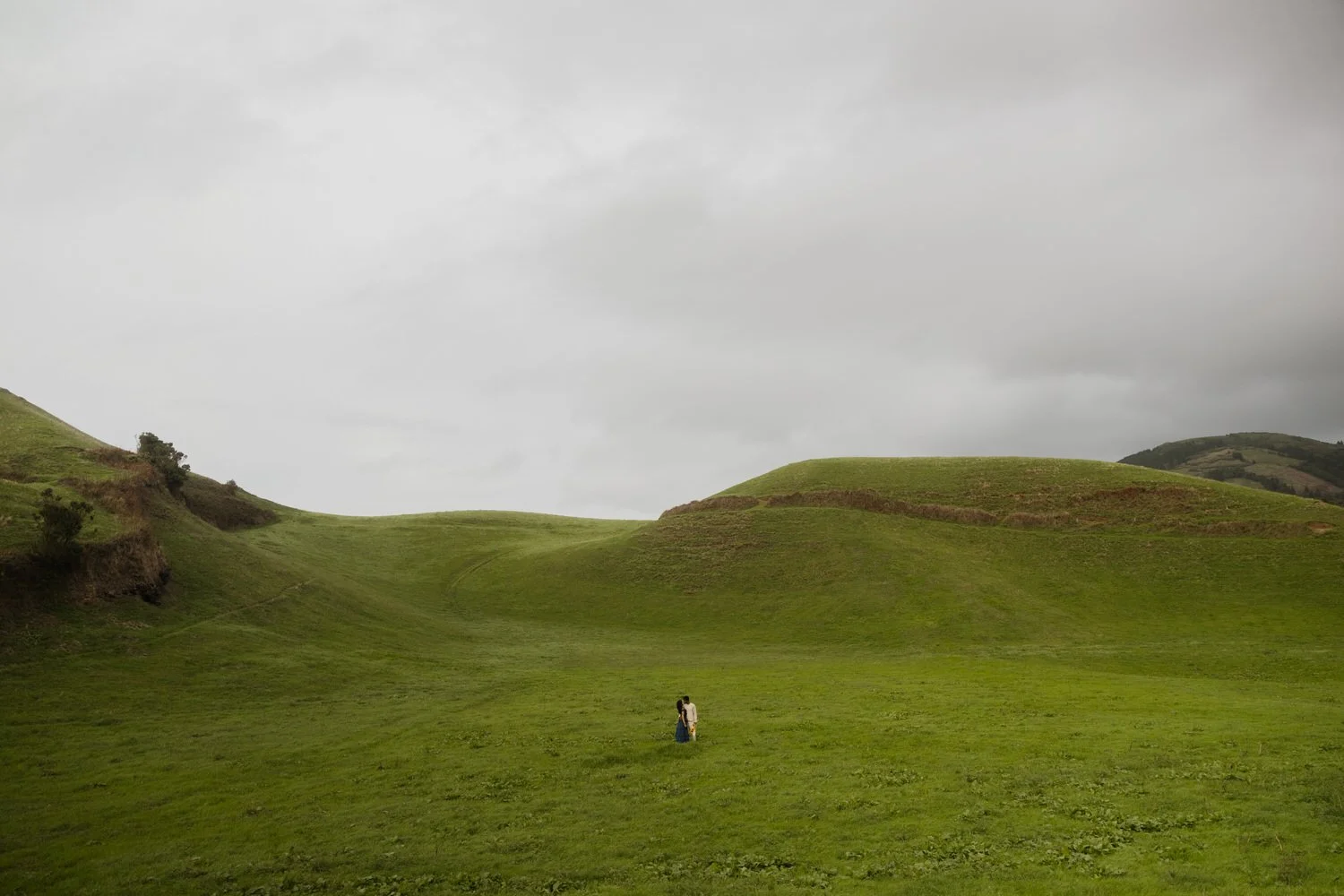 Couple standing in a hidden green valley in São Miguel Azores during surprise proposal journey