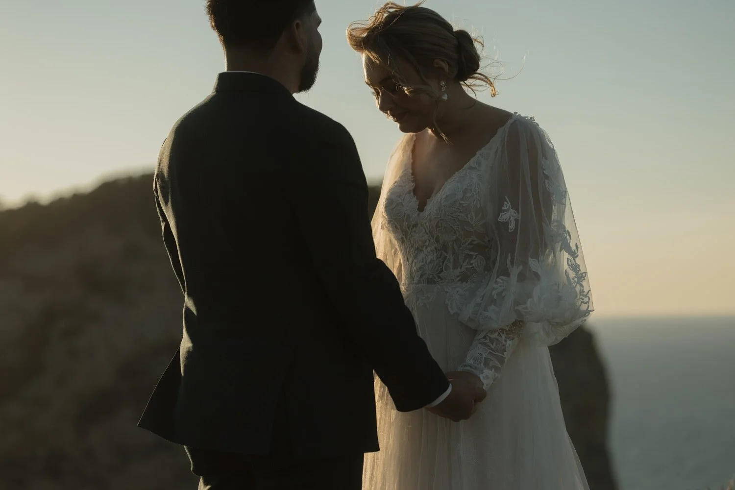 Bride and groom holding hands during their intimate cliffside wedding ceremony at Cap de Formentor, Mallorca.