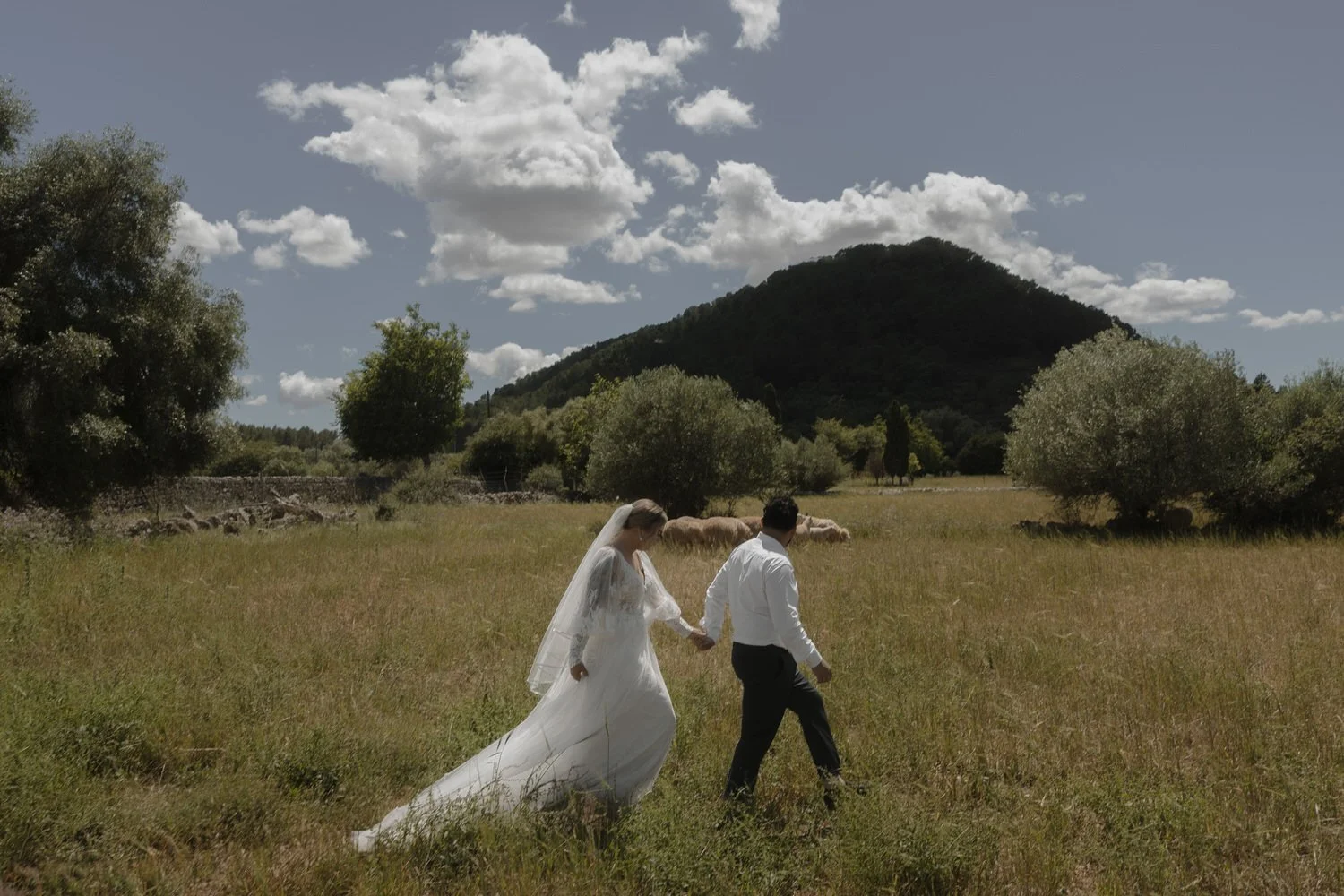 Bride and groom walking hand in hand through the Mallorcan countryside