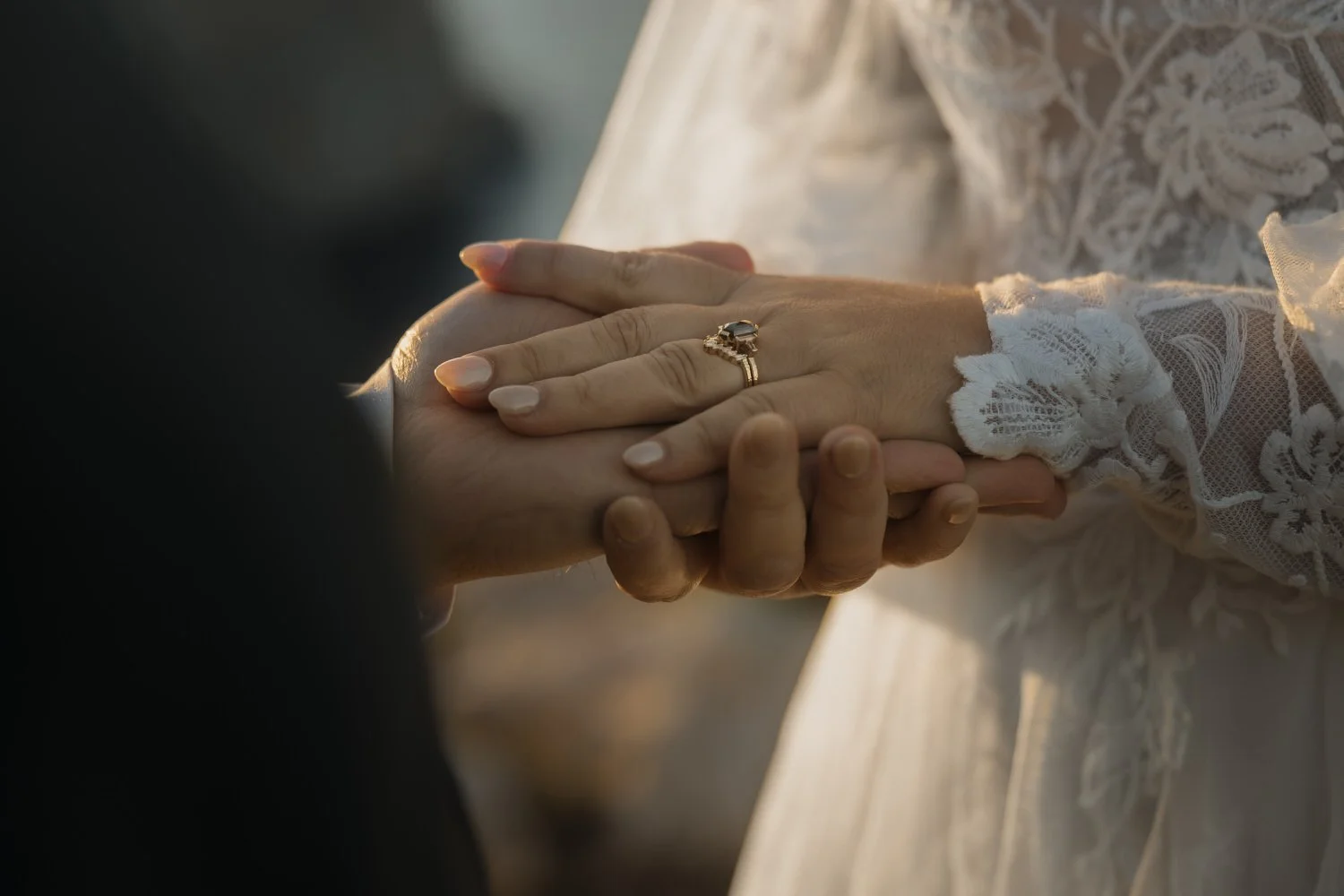 Close-up of the couple holding hands during their intimate elopement ceremony in Mallorca, with the wedding rings in focus.