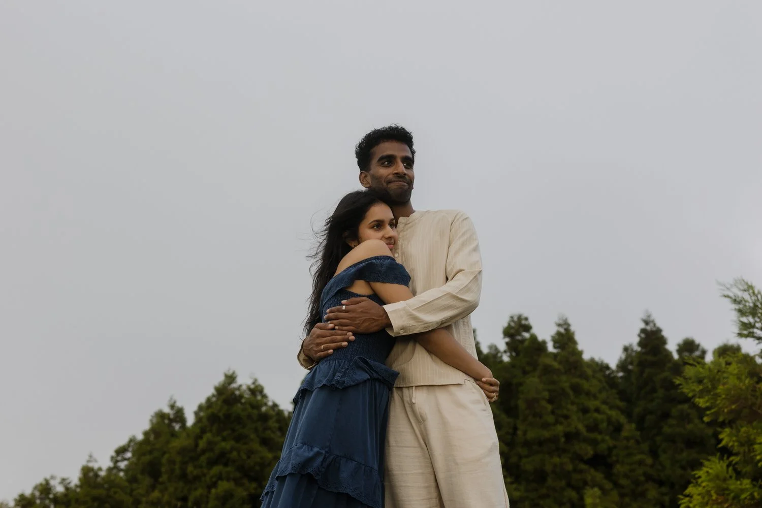 engaged couple embracing on a hill in São Miguel Azores after a proposal