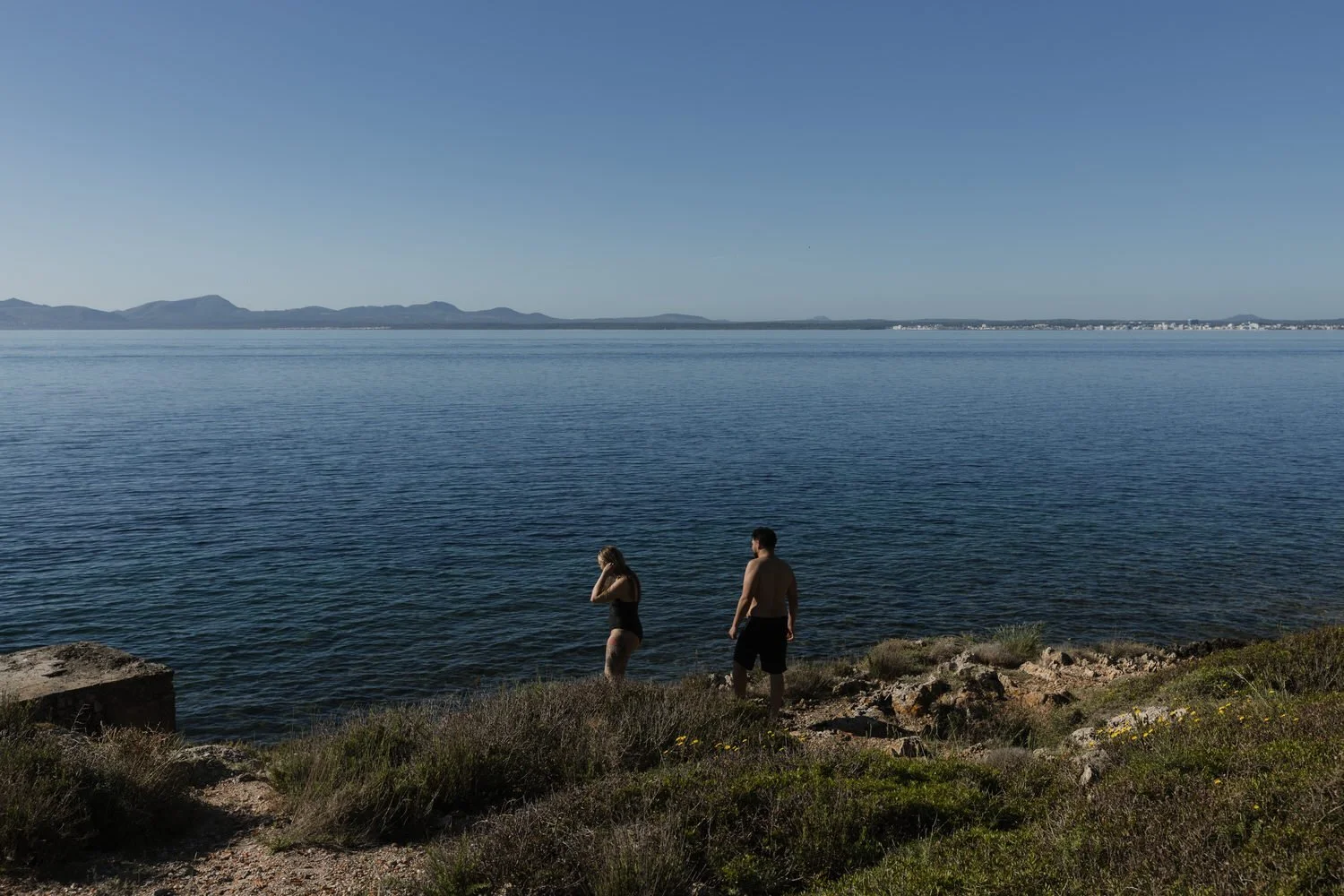 Couple exploring the coastline during a sunrise experience in Mallorca.